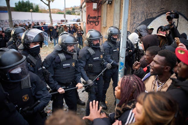 <p>Migrants confront police as they begin carrying out eviction orders at an abandoned school building where hundreds of mostly undocumented migrants had been living in Badalona</p>