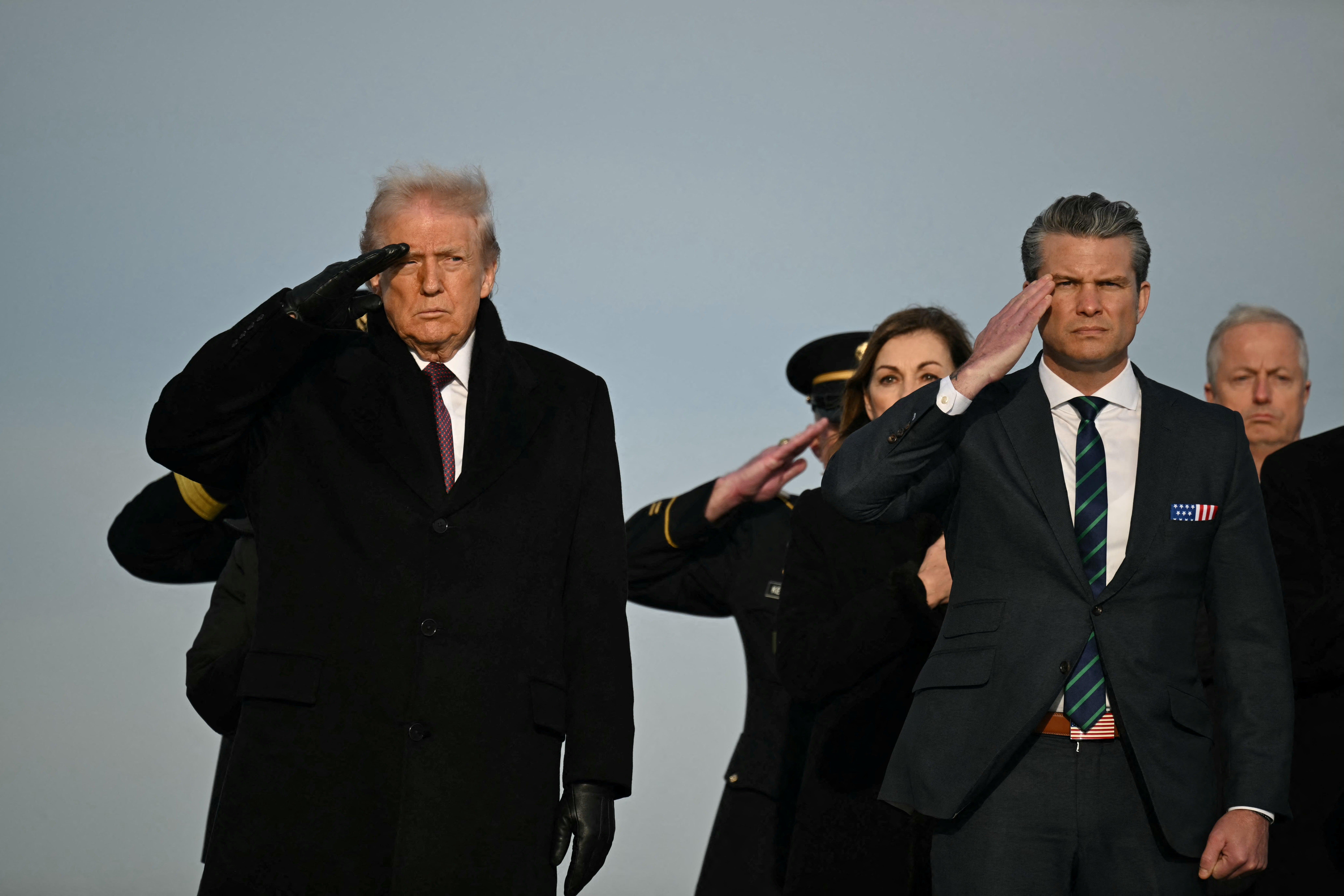 <p>President Donald Trump and Defense Secretary Pete Hegseth salute as they observe the return of the remains of two Iowa National Guard members killed in an attack in Syria during a ceremony at Dover Air Force Base in Delaware</p>