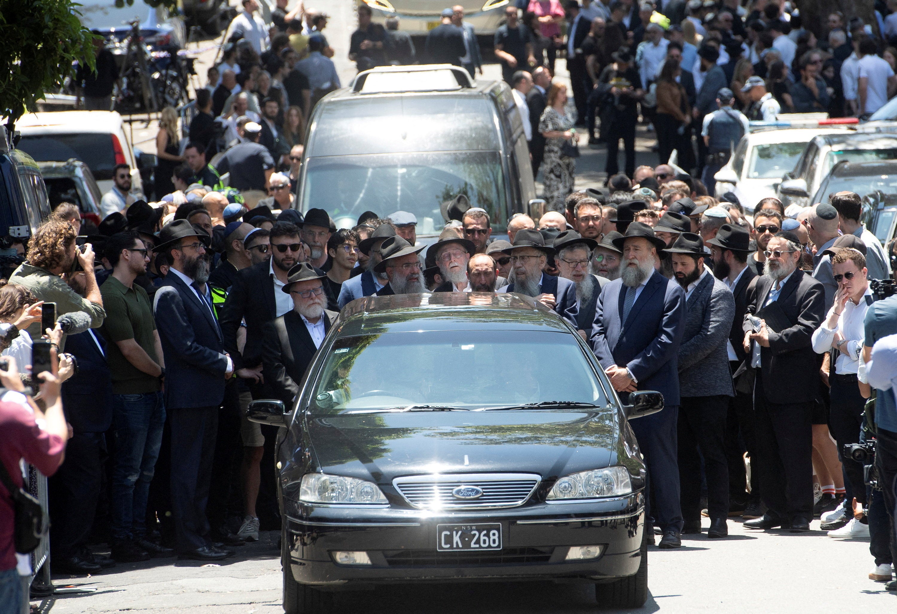Mourners attend the funeral of Rabbi Eli Schlanger