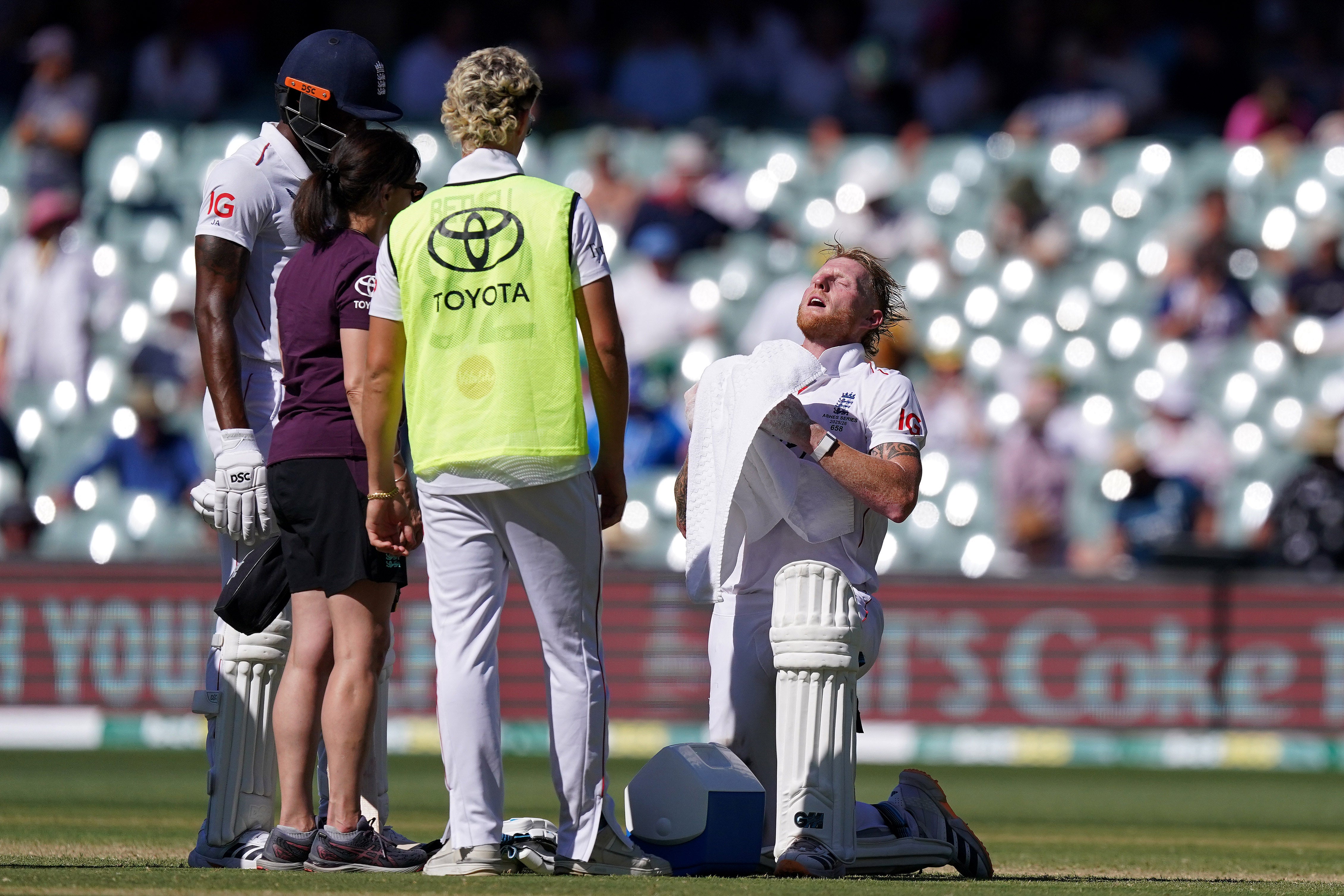 <p>Ben Stokes (right) tries to cool himself down with a towel while batting in hot temperatures on day two</p>