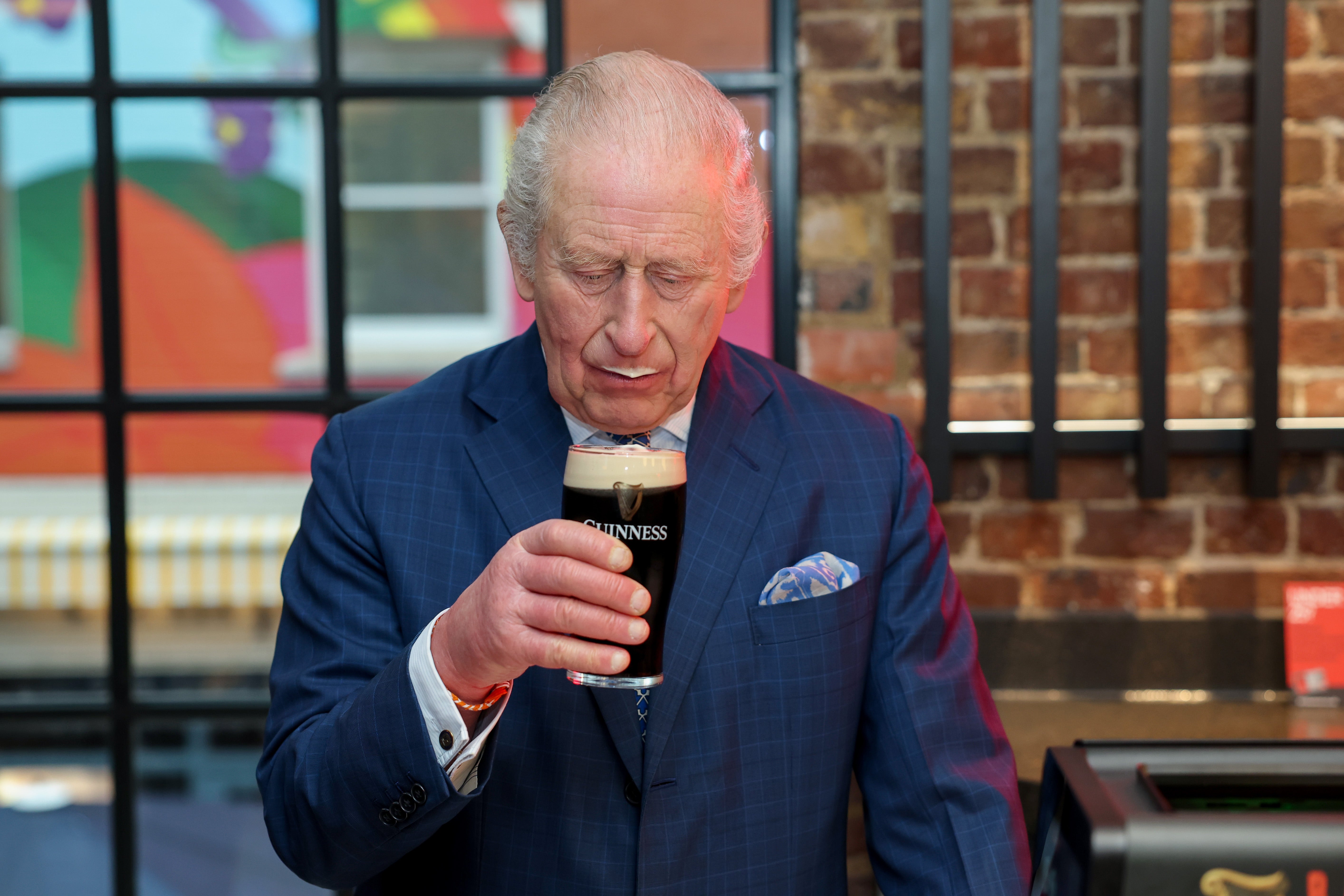 King Charles III tastes a pint of Guinness during his visit to the Guinness Open Gate Brewery in London