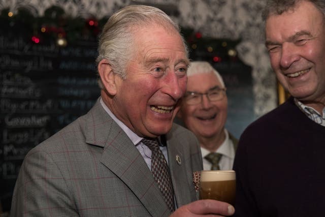 Charles with half a pint of Guinness during a visit to the Fleece Inn, a community pub supported by the Pub is The Hub initiative, in Wotton-under-Edge, Gloucestershire (PA)