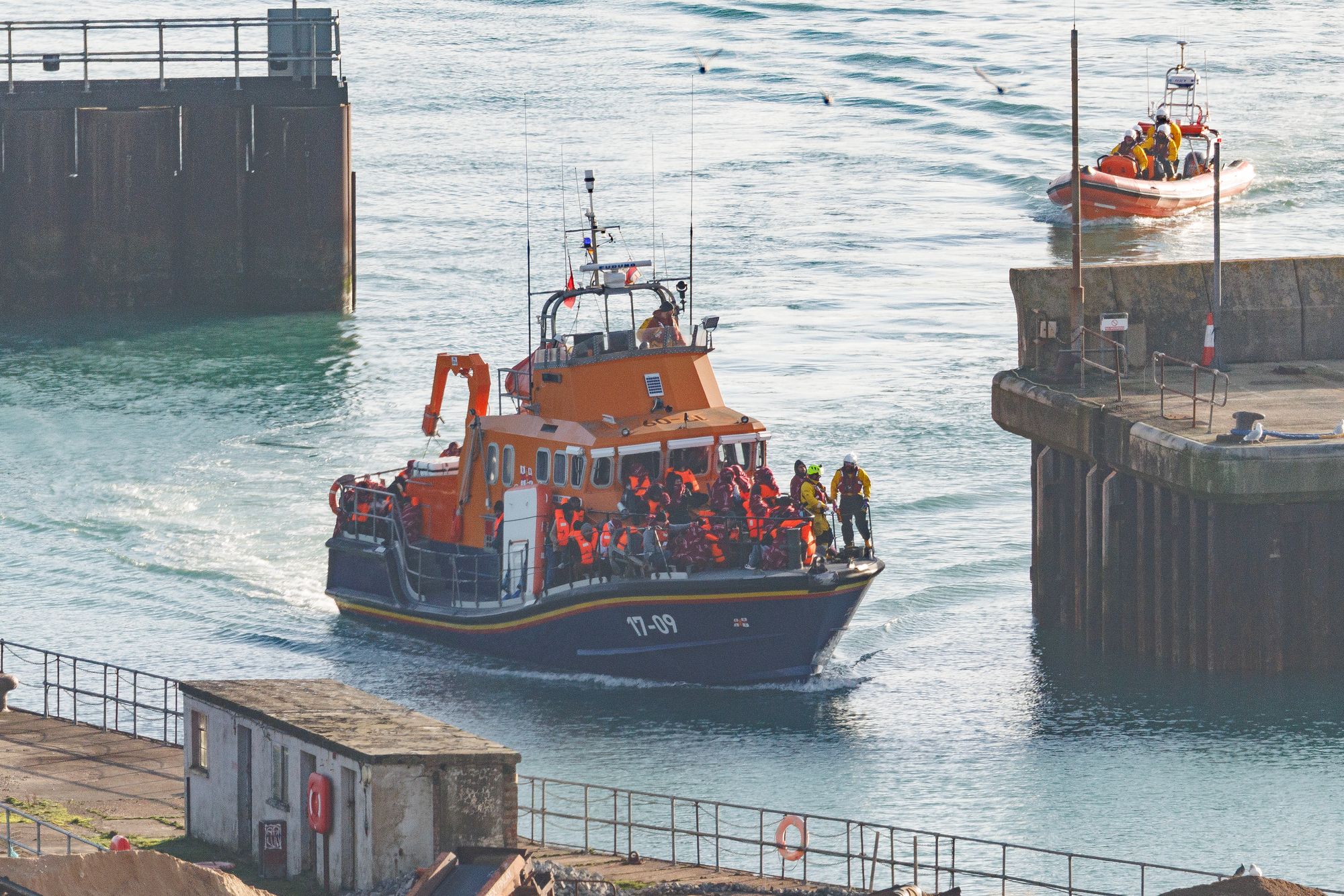 An RNLI lifeboat delivers migrants to Dover port after intercepting a small boat crossing on December 17, 2025 in Dover, England.