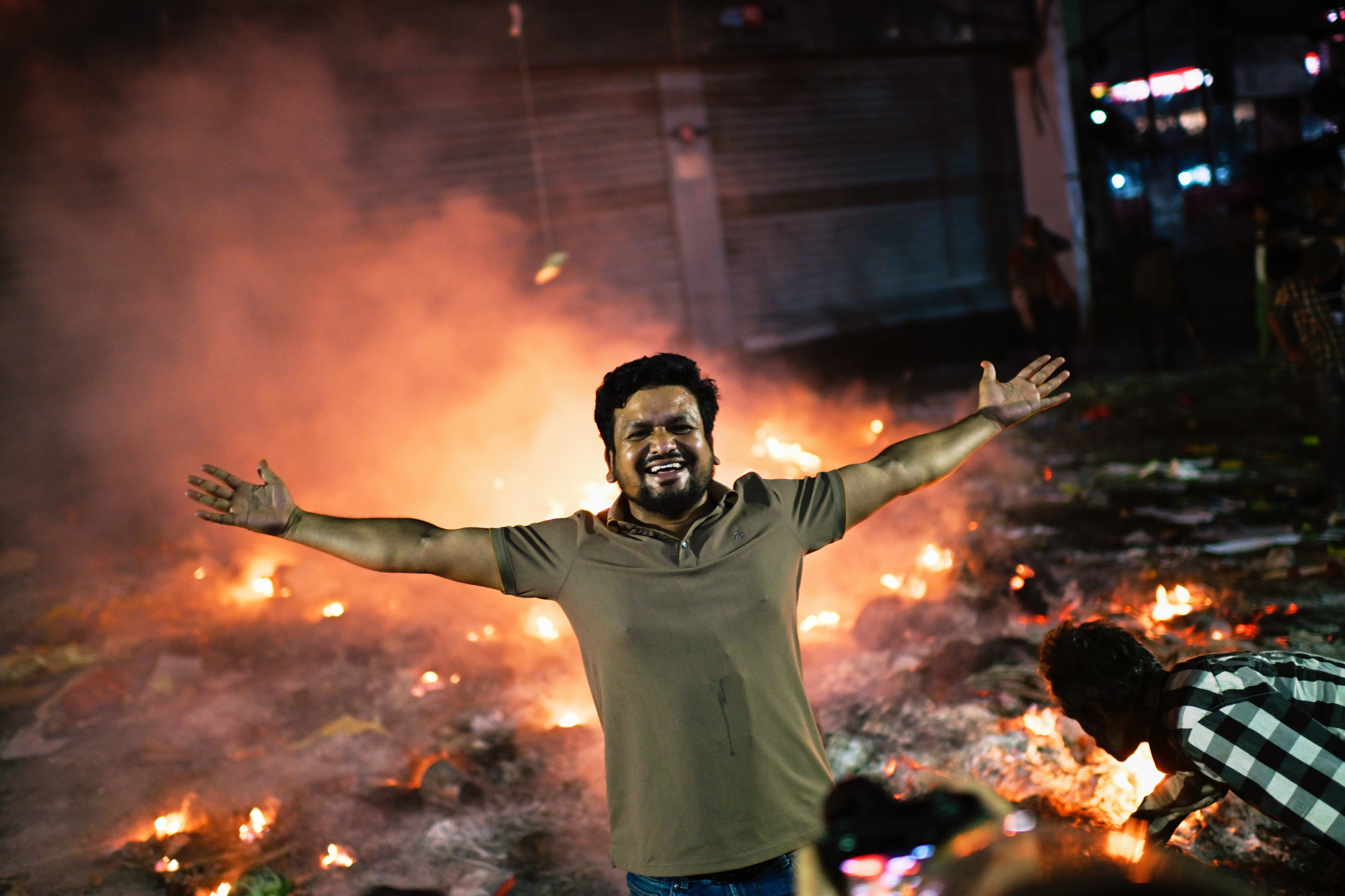 A protester reacts to the camera near the premises of the Prothom Alo daily newspaper which was set on fire by angry protesters