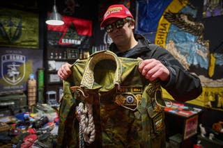 O artista de rua ucraniano Maxim Kilderov segura um uniforme cerimonial russo em seu museu particular