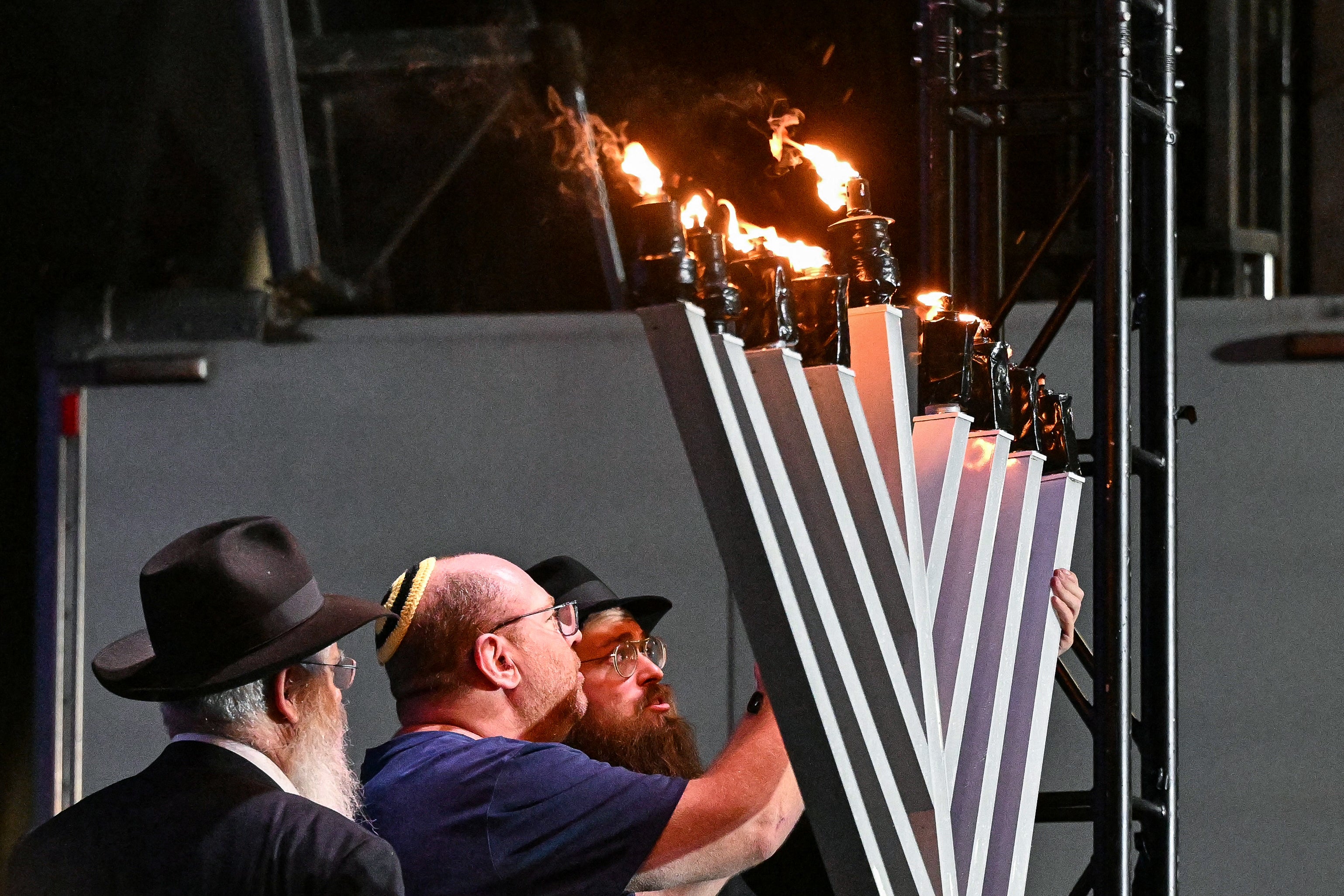 The father, centre, of 10-year-old victim Matilda, lights a candle on Sunday