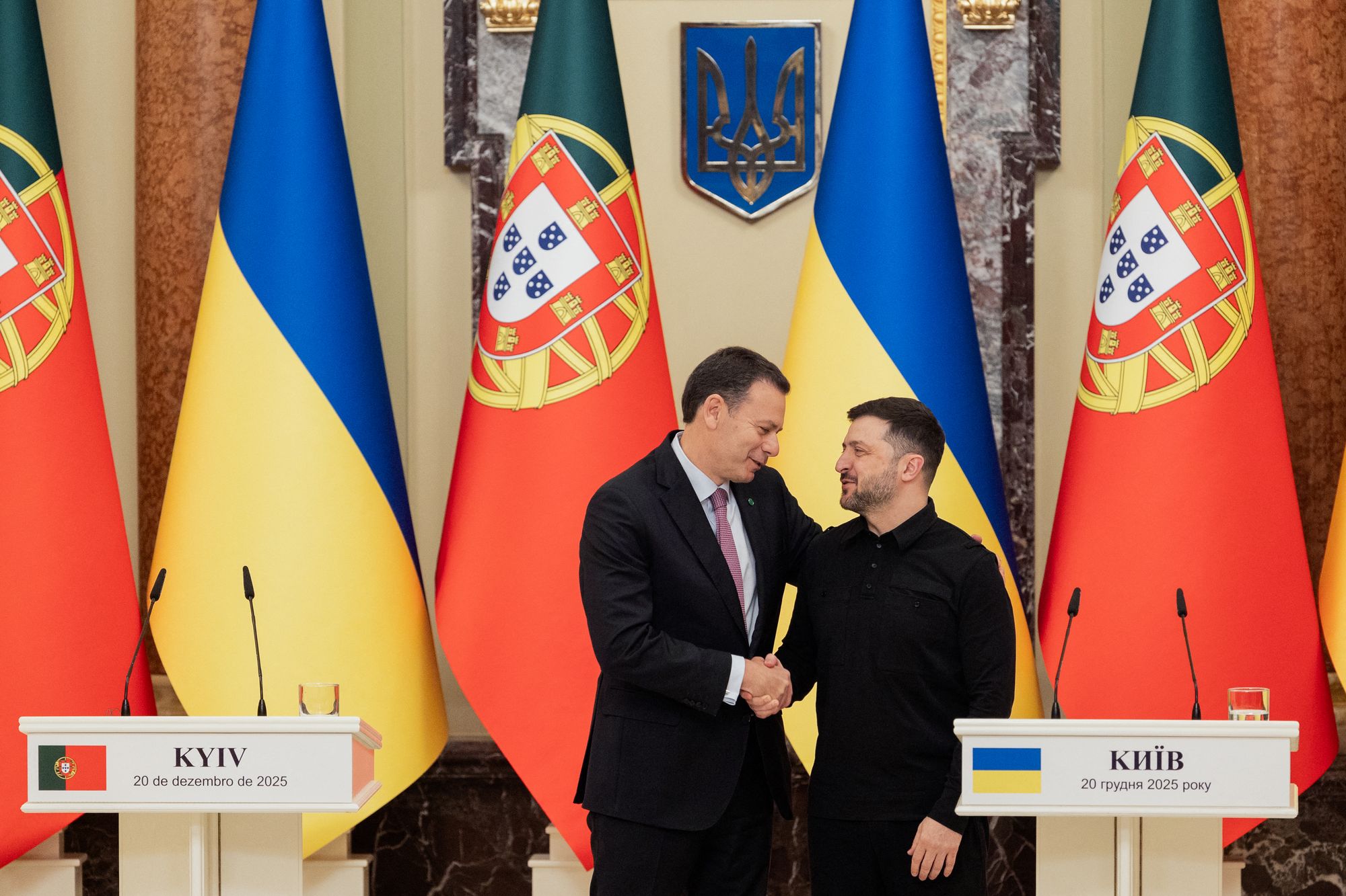 Ukraine's President Volodymyr Zelensky (R) shakes hands with Portugal's Prime Minister Luis Montenegro (R) after joint press conference