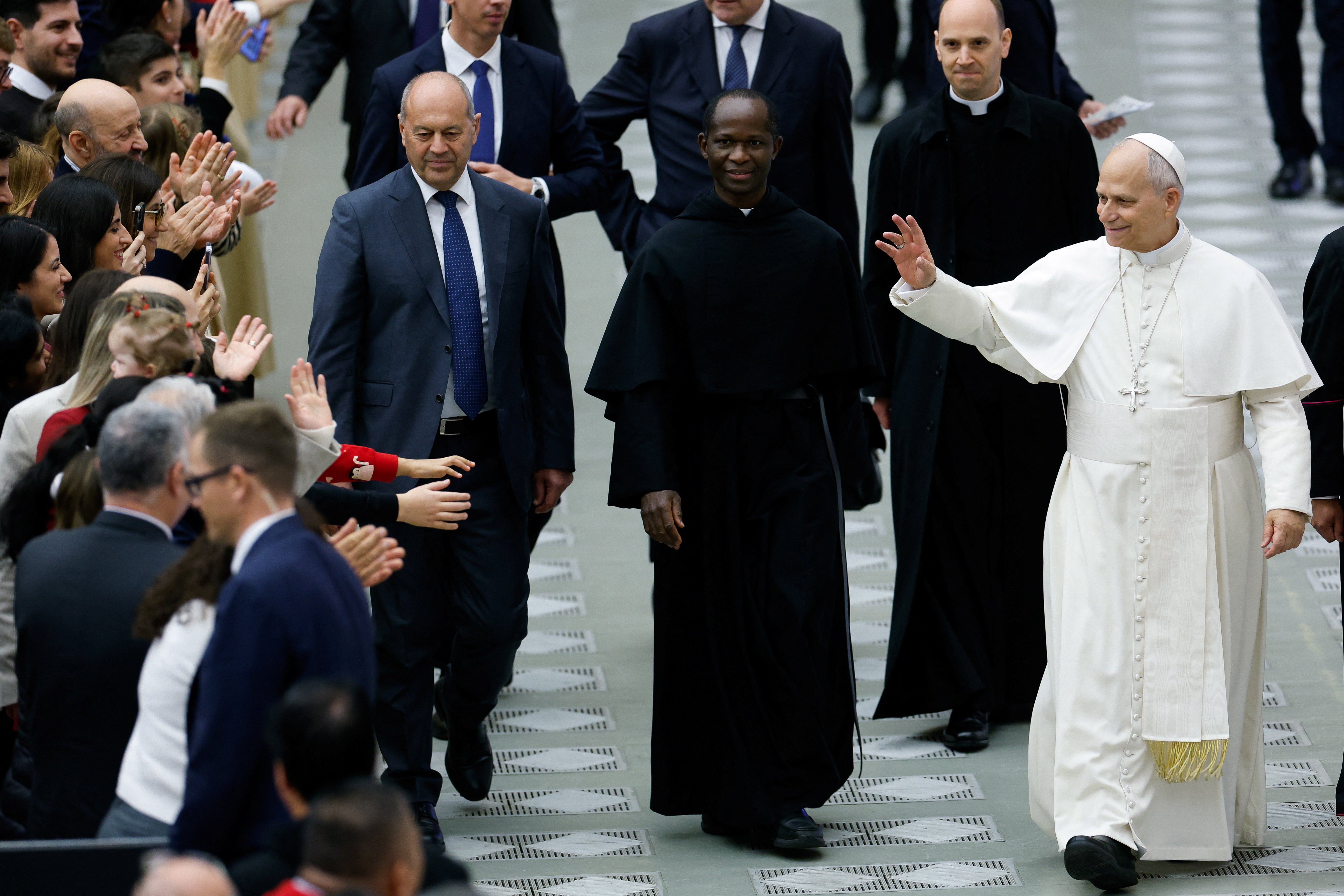 Pope Leo XIV greets the audience at the end of a meeting with employees of the Roman Curia, the Governorate of the Vatican City State, and the Vicariate of Rome and their families