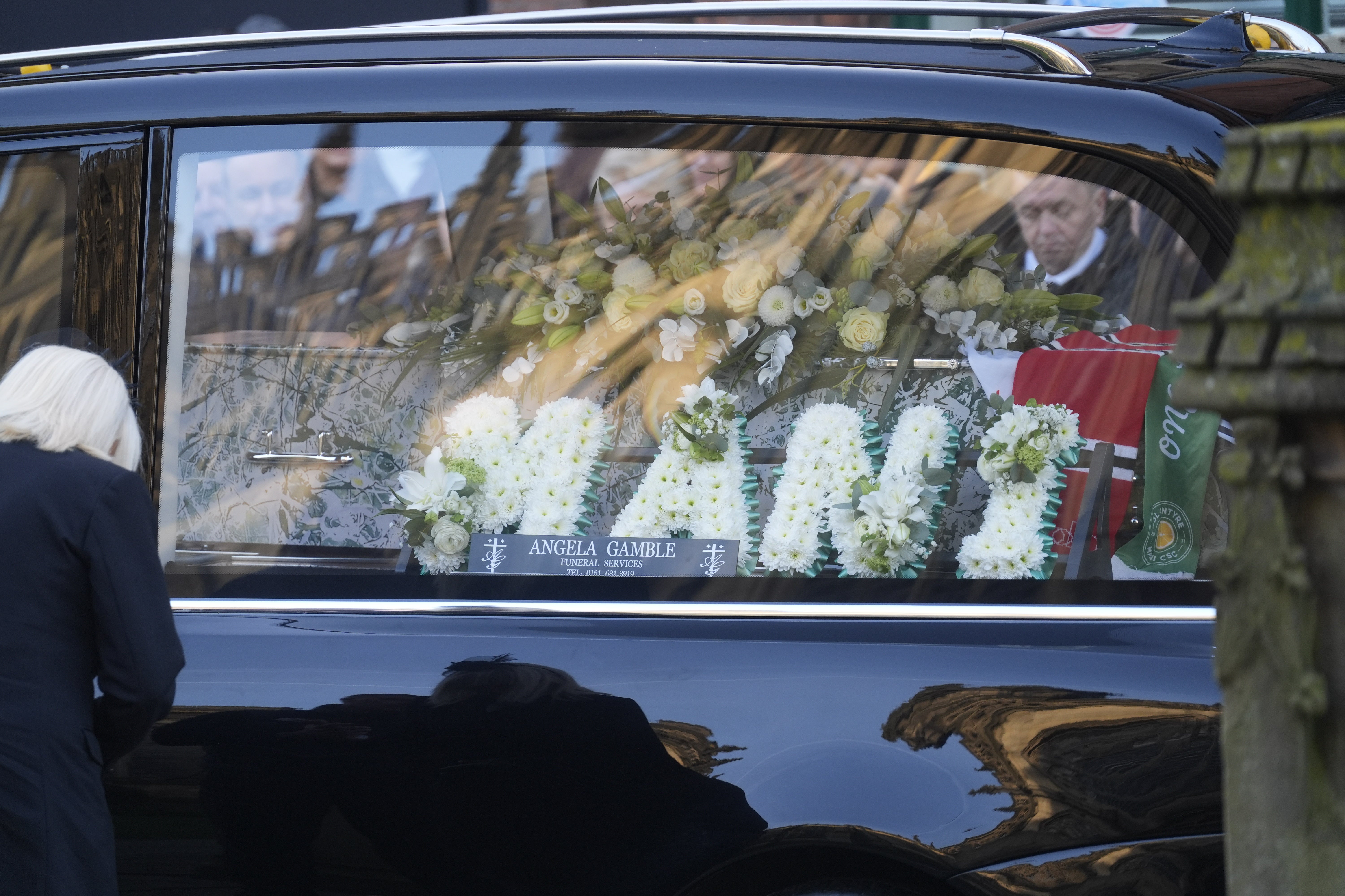 Flowers reading ‘Mani’ in the hearse as it arrives for the funeral service.