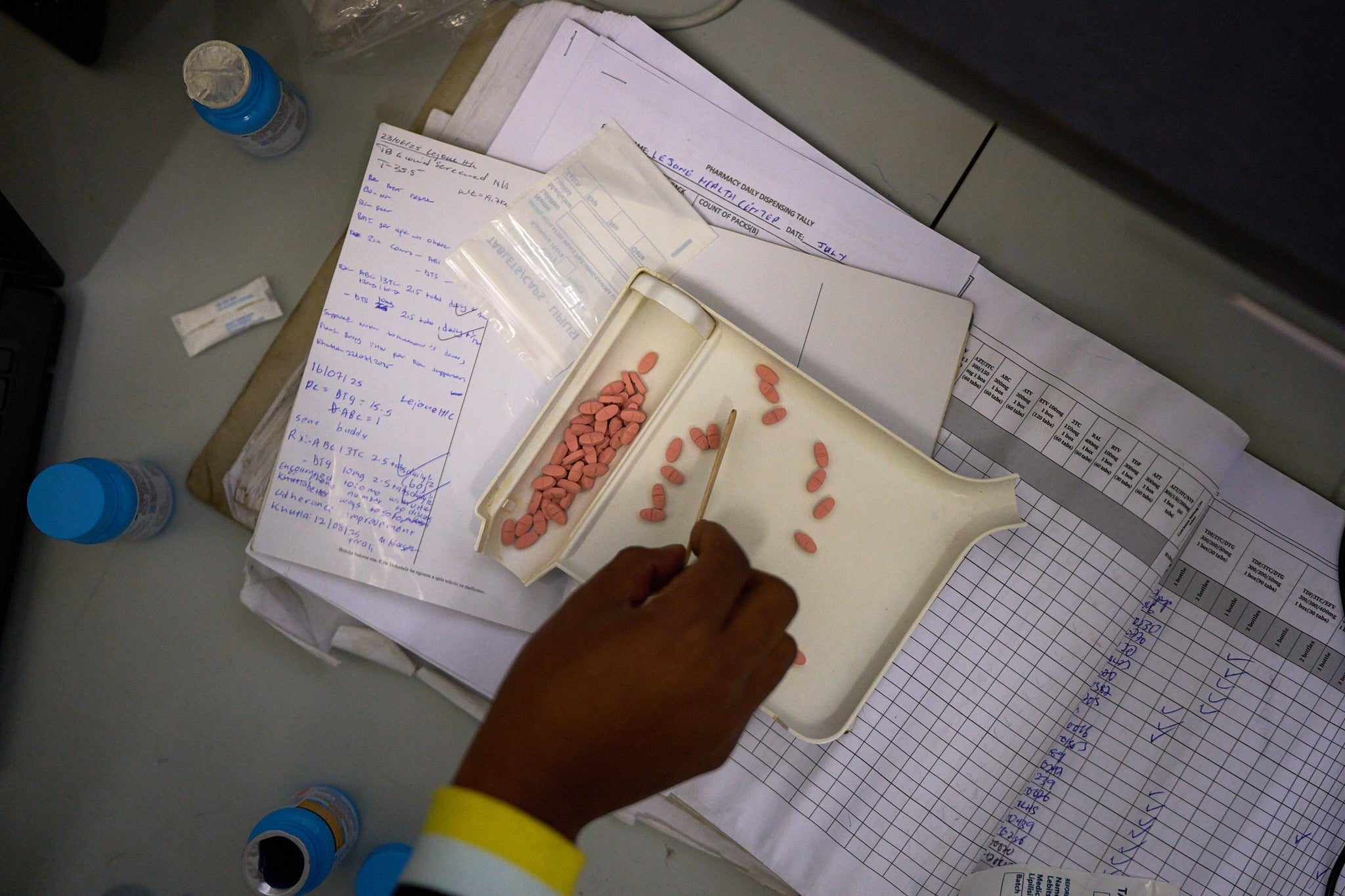 A pharmacist counts HIV medicine inside a clinic in Ha Lejone, Lesotho