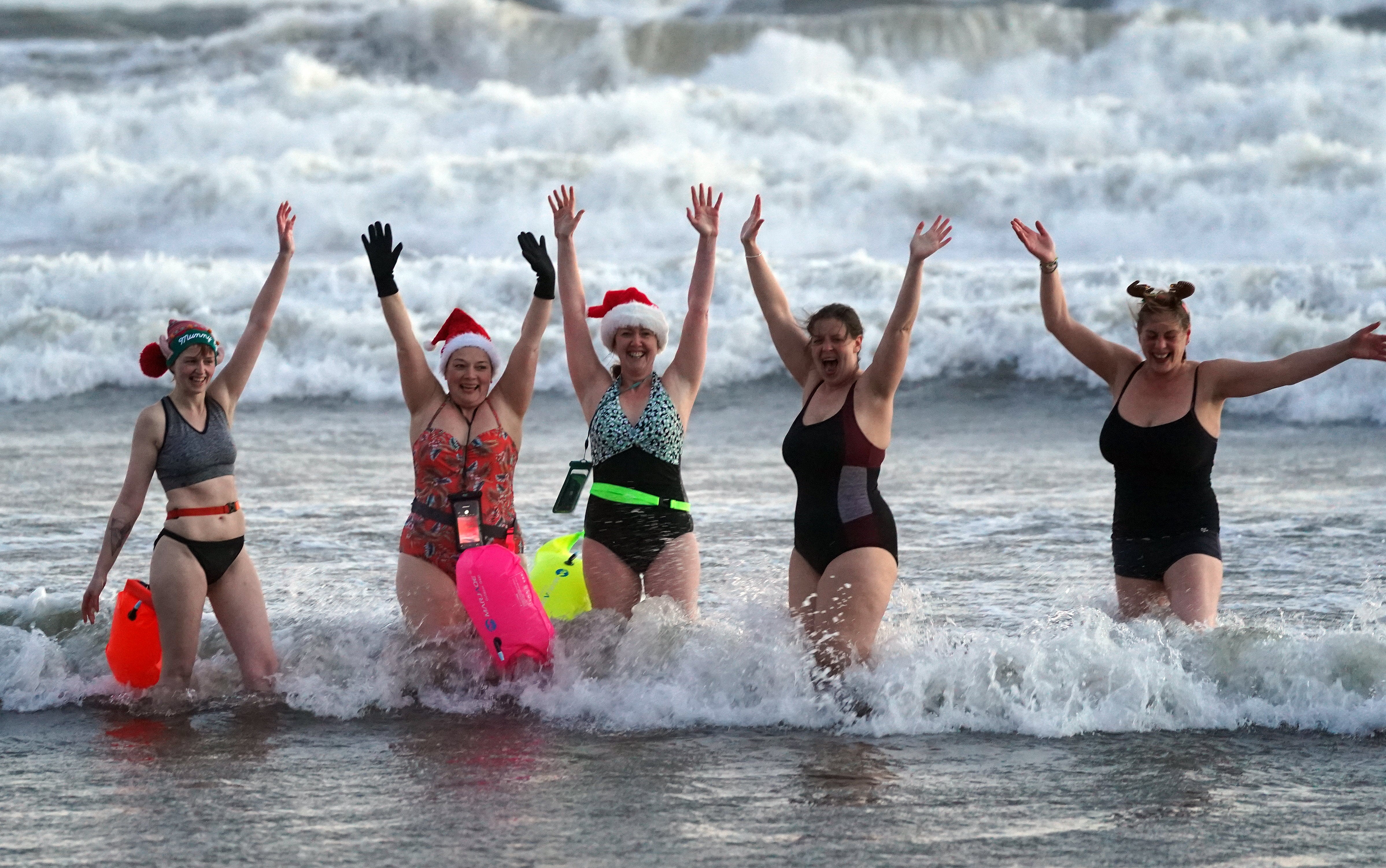 Swimmers go for a Christmas Day dip at Tynemouth beach, north-east England (Owen Humphreys/PA)