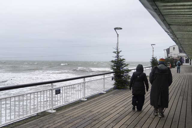 <p>People dressed up for the cold as they walk along Bournemouth pier in Dorset (PA)</p>