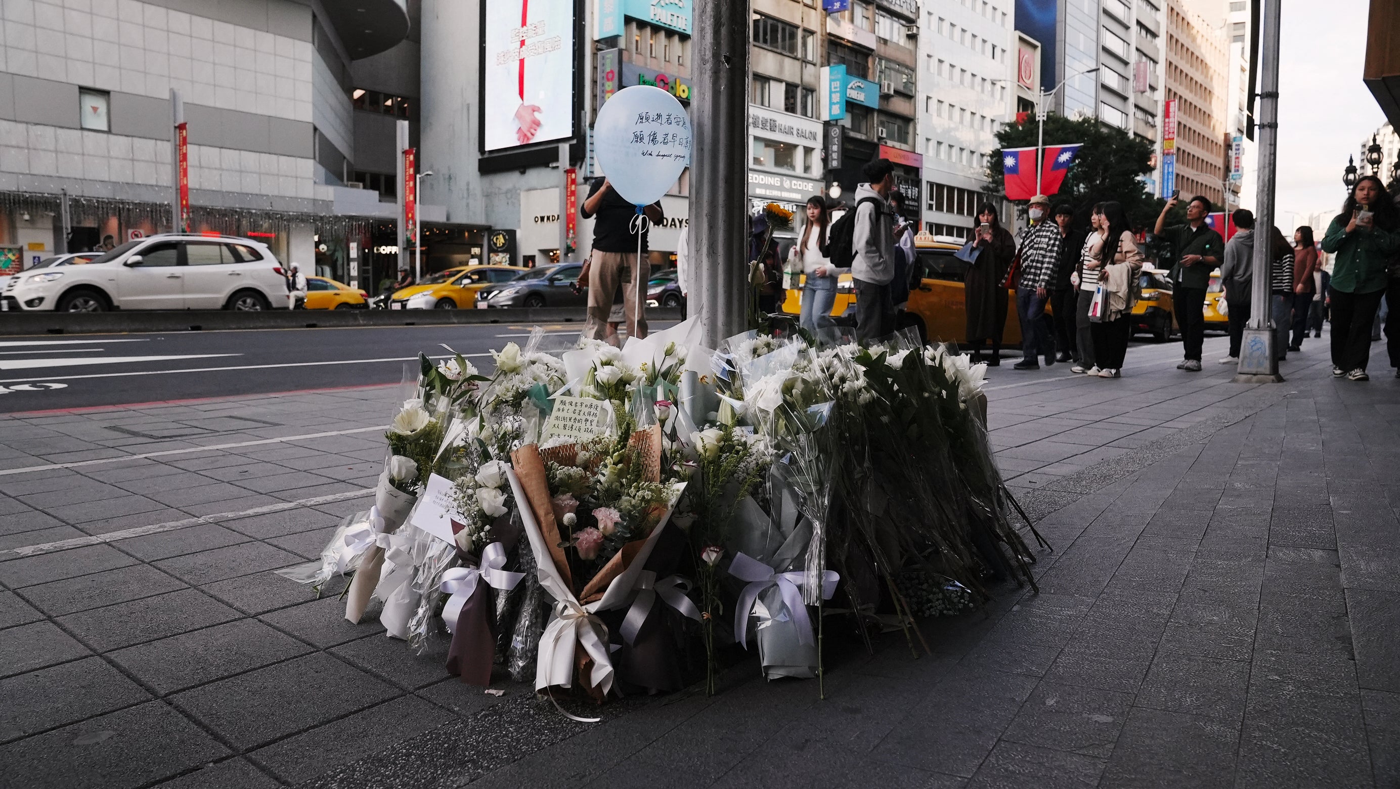 Flowers and notes from the public are laid for the victims of the metro attack outside a mall in Taipei on 20 December 2025. Taiwan’s president Lai Ching-te pledged a full, public enquiry into a deadly metro stabbing attack as he visited victims in the hospital on 20 December