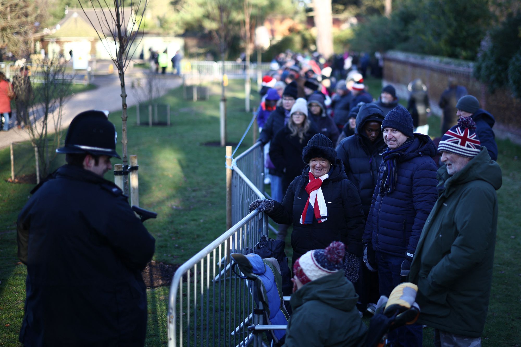 Well-wishers wait for members of Britain's Royal Family to arrive to attend the traditional Christmas Day service at St Mary Magdalene Church