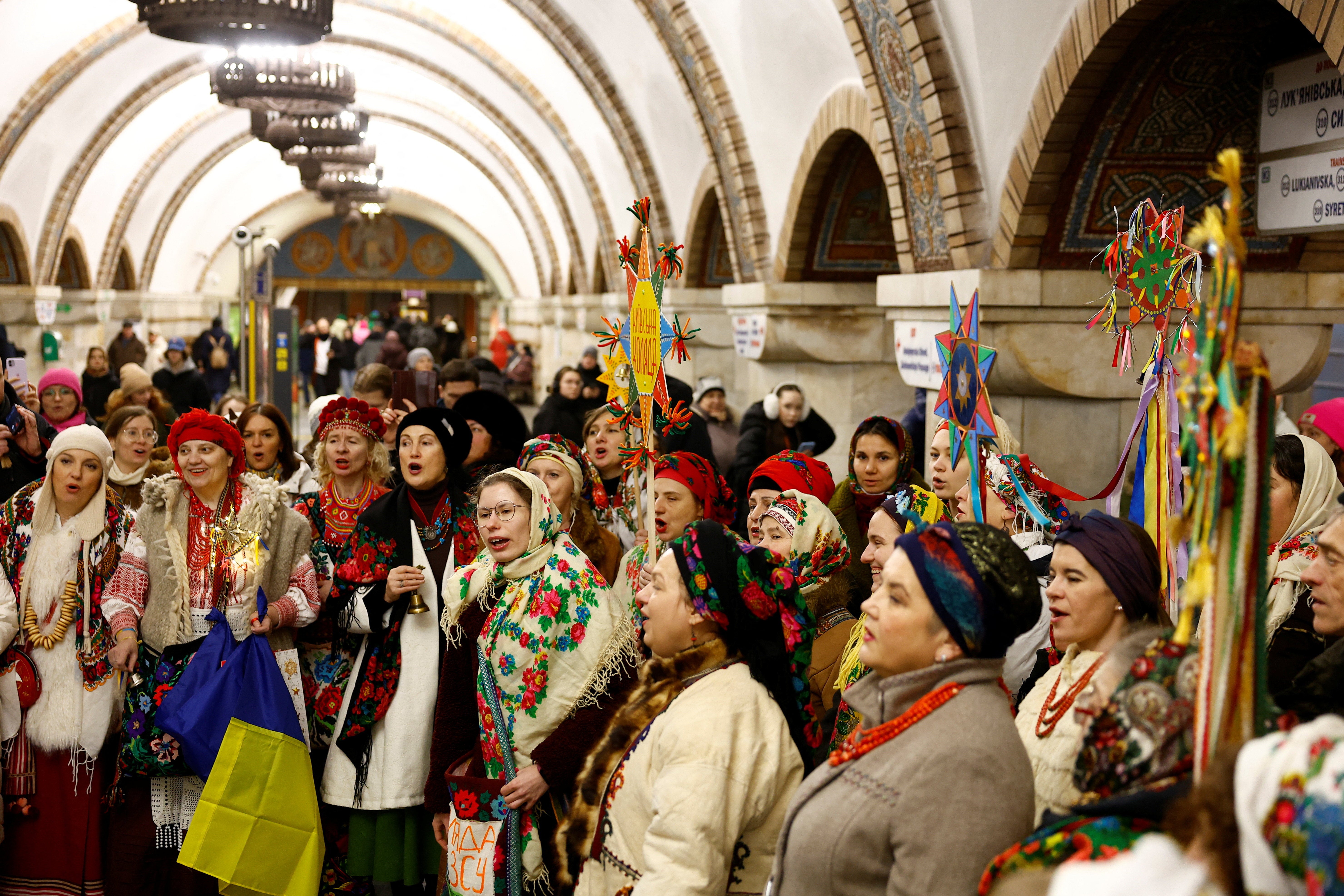 Residents dressed in traditional clothes sing carols inside a metro station during the Christmas celebrations