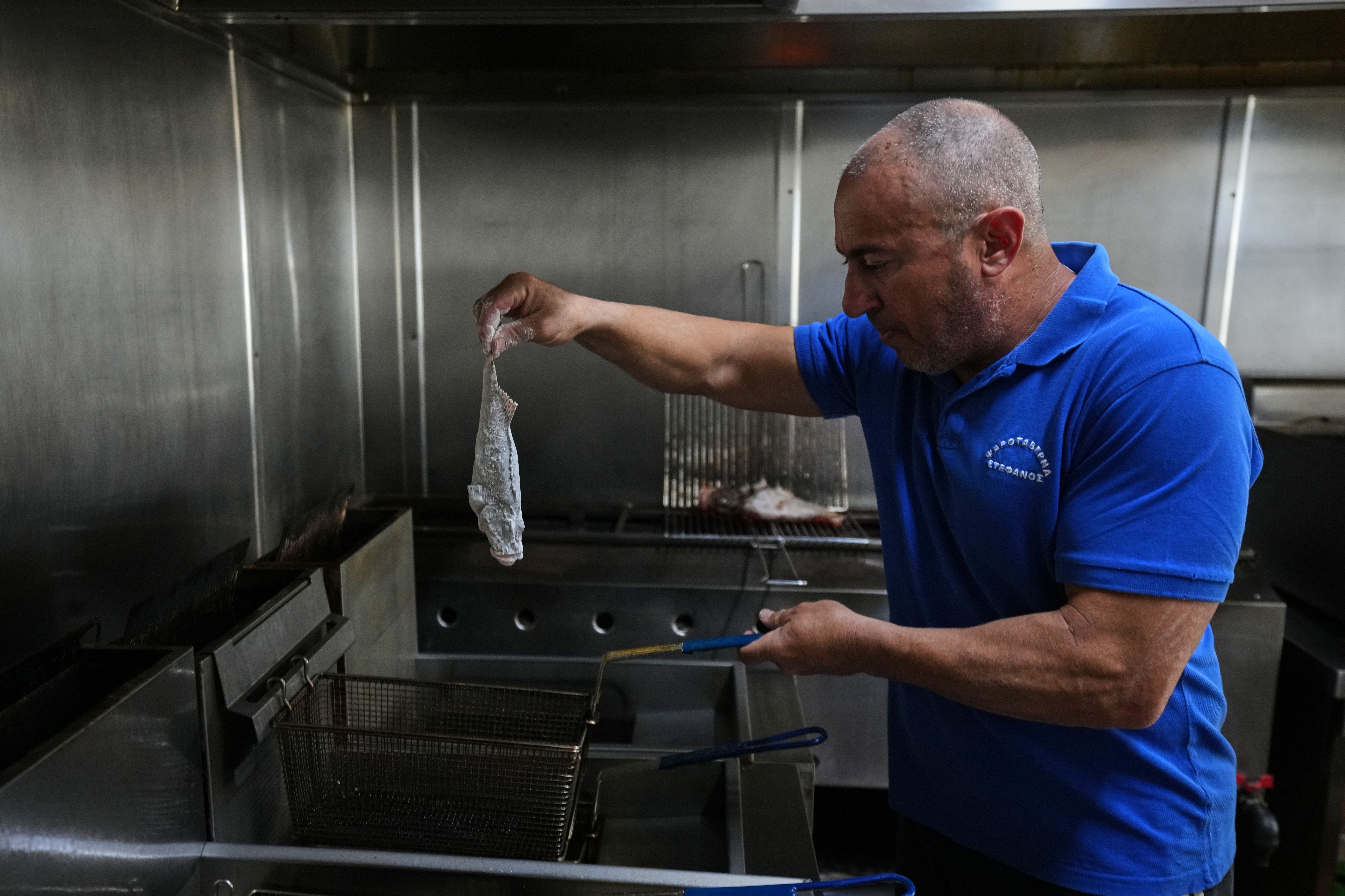 Stefanos Mentonis, owner of Stefanos restaurant, cooks lionfish