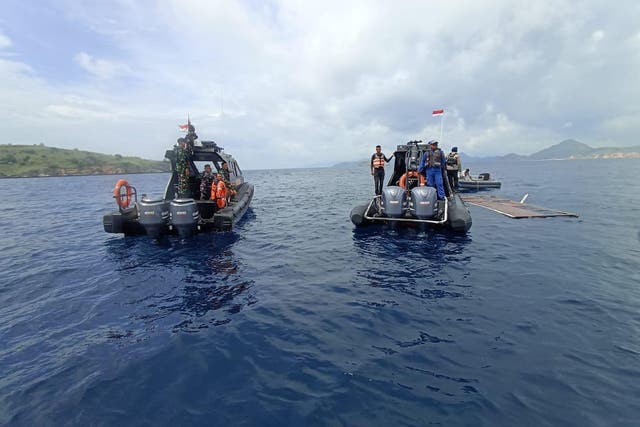 <p>Indonesian National Search and Rescue Agency workers examine debris in the water after the boat capsized</p>