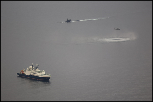 An anti-submarine Merlin Mk2 helicopter could be seen tracking the ship