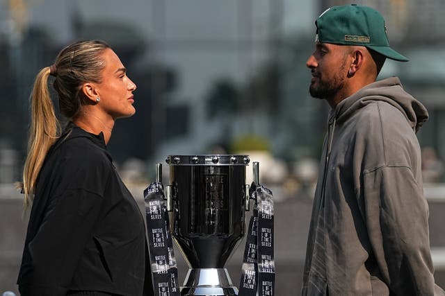 <p>Tennis players Aryna Sabalenka of Belarus, left, and Nick Kyrgios of Australia face off with the trophy ahead of the Battle of the Sexes exhibition match</p>