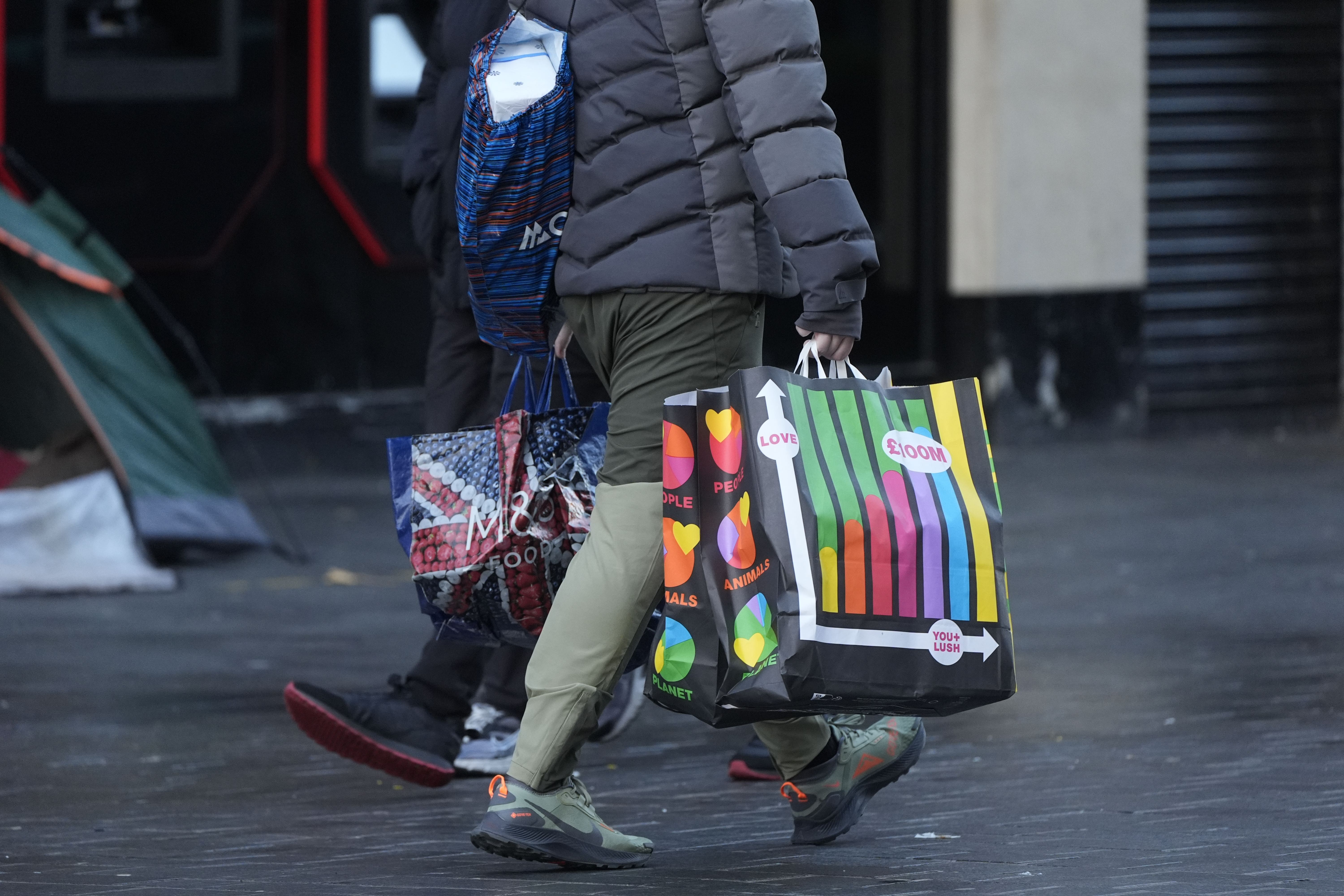 A person carries bags of shopping through the city centre in Liverpool during the Boxing Day sales (PA)