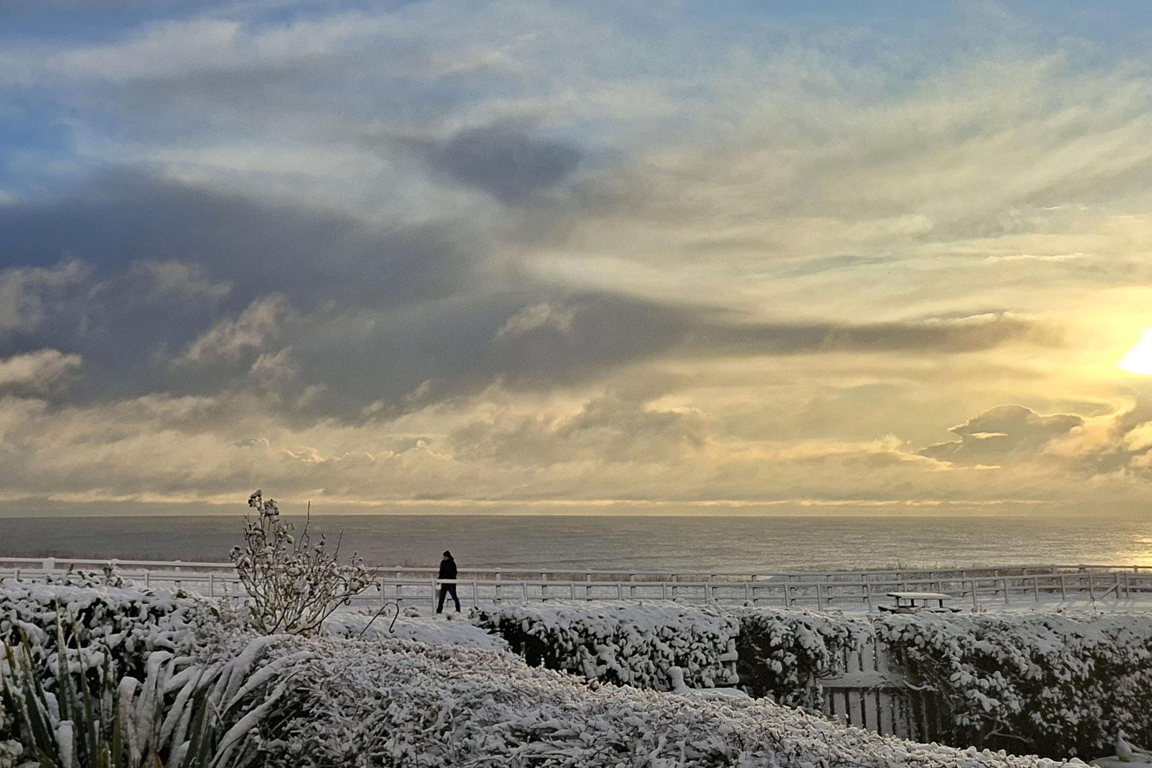 The sun rises over the snowy conditions on the East Yorkshire coast, near Skipsea (Amy Crowther/PA)
