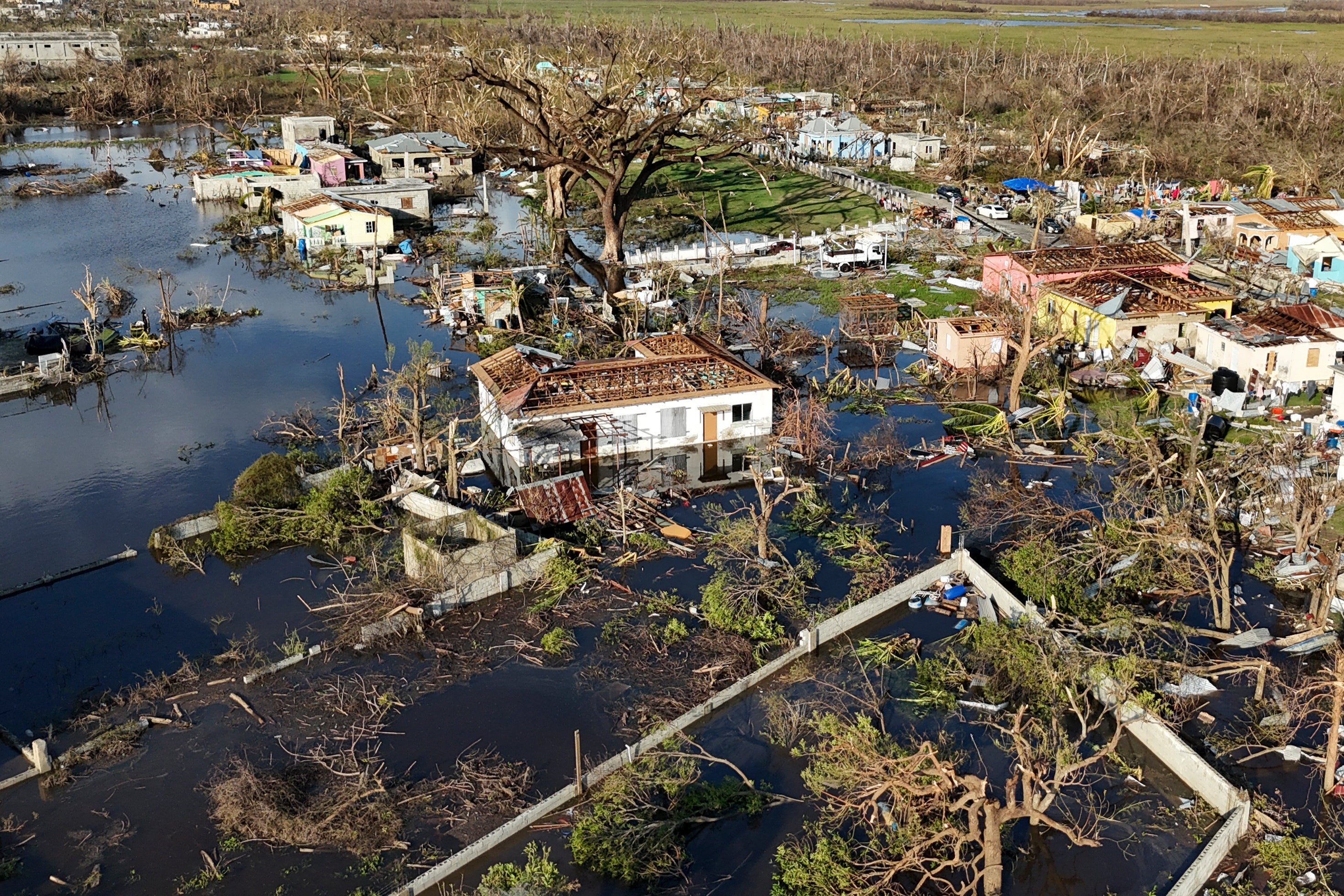 Debris surrounds damaged homes along the Black River, Jamaica, Thursday, Oct. 30, 2025, in the aftermath of Hurricane Melissa