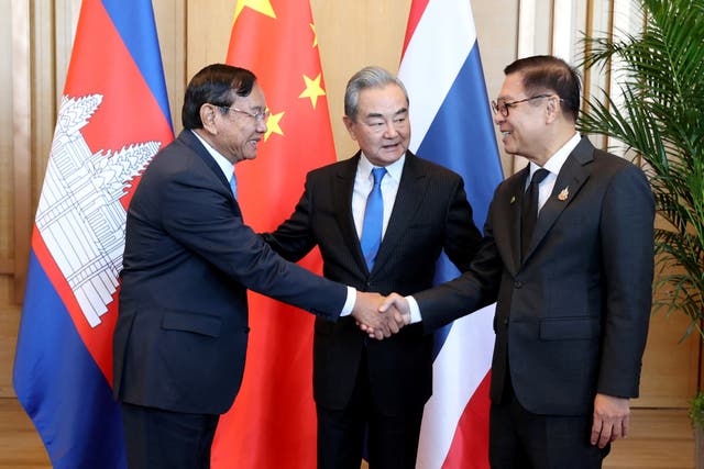 <p>Chinese foreign minister Wang Yi, centre, looks at Cambodia’s Prak Sokhonn while he shakes hands with Thailand’s Sihasak Phuangketkeow during a meeting in Yunnan province</p>