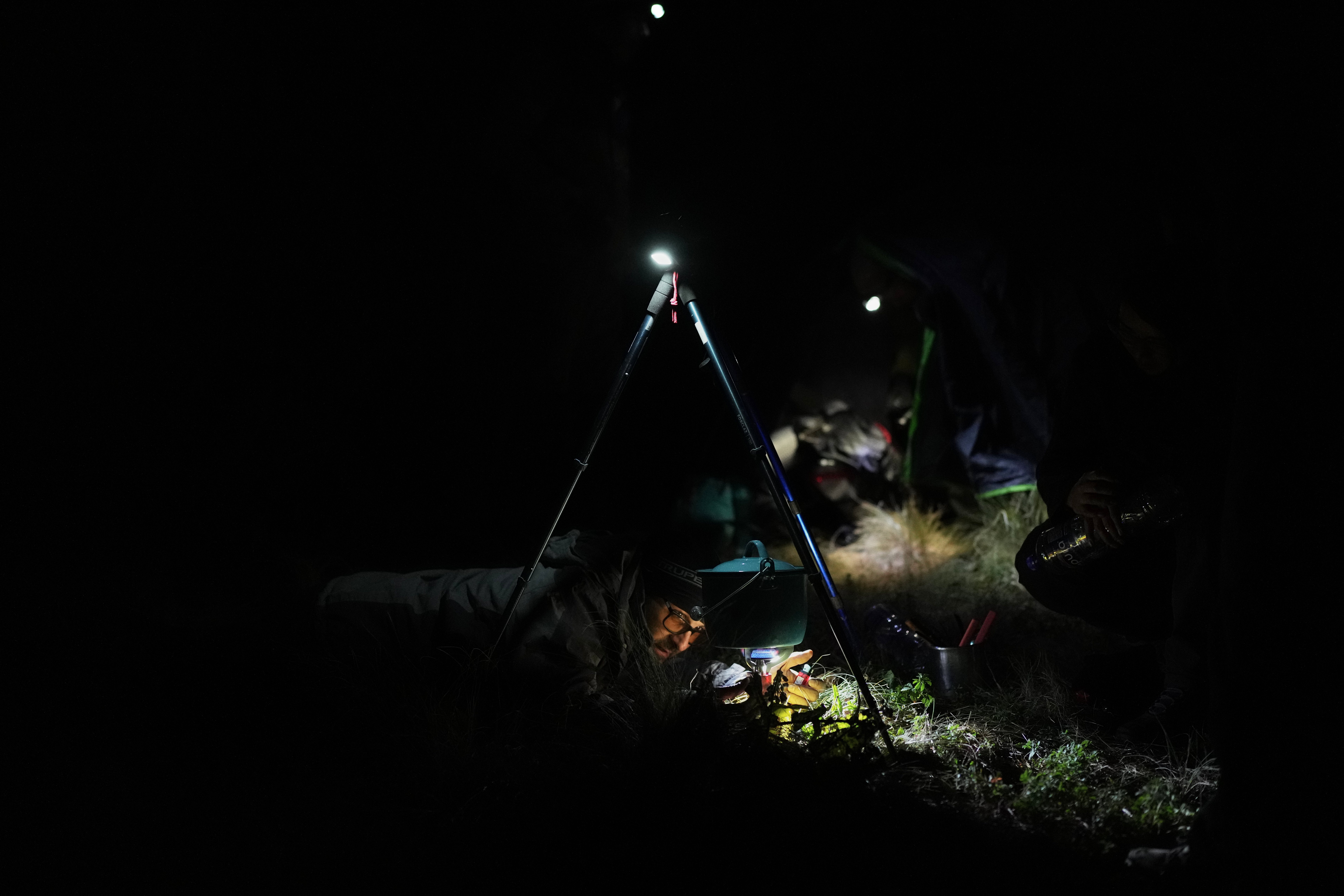 Marco Calo, a geophysicist at the National Autonomous University of Mexico (UNAM), prepares food at the campsite on the slopes of the Popocatepetl volcano, Mexico, Thursday, Dec. 4, 2025. (AP Photo/Eduardo Verdugo)