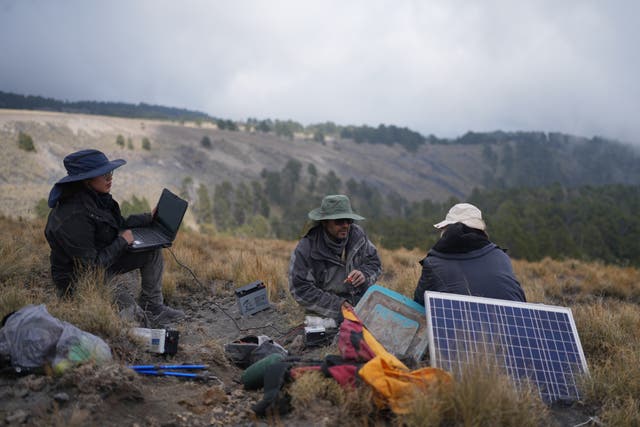 <p>Karina Rodriguez, left, a master's student, and Marco Calo, center, a geophysicist at the National Autonomous University of Mexico (UNAM), collect information from a monitoring station on the slopes of the Popocatepetl volcano in Mexico, Friday, Dec. 5, 2025. (AP Photo/Eduardo Verdugo)</p>