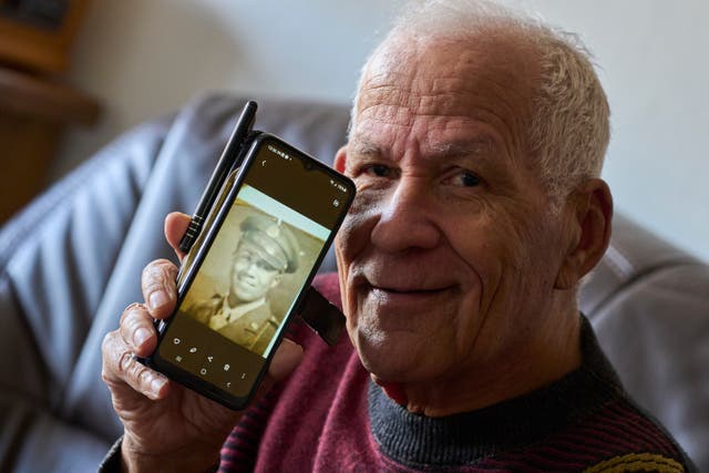 <p>Seventy-nine-year-old Cor Linssen, son of a Black WWII soldier and a White mother, shows a picture of his father on his mobile phone during an interview in Roermond, Netherlands, Thursday, Dec. 11, 2025. (AP Photo/Peter Dejong)</p>