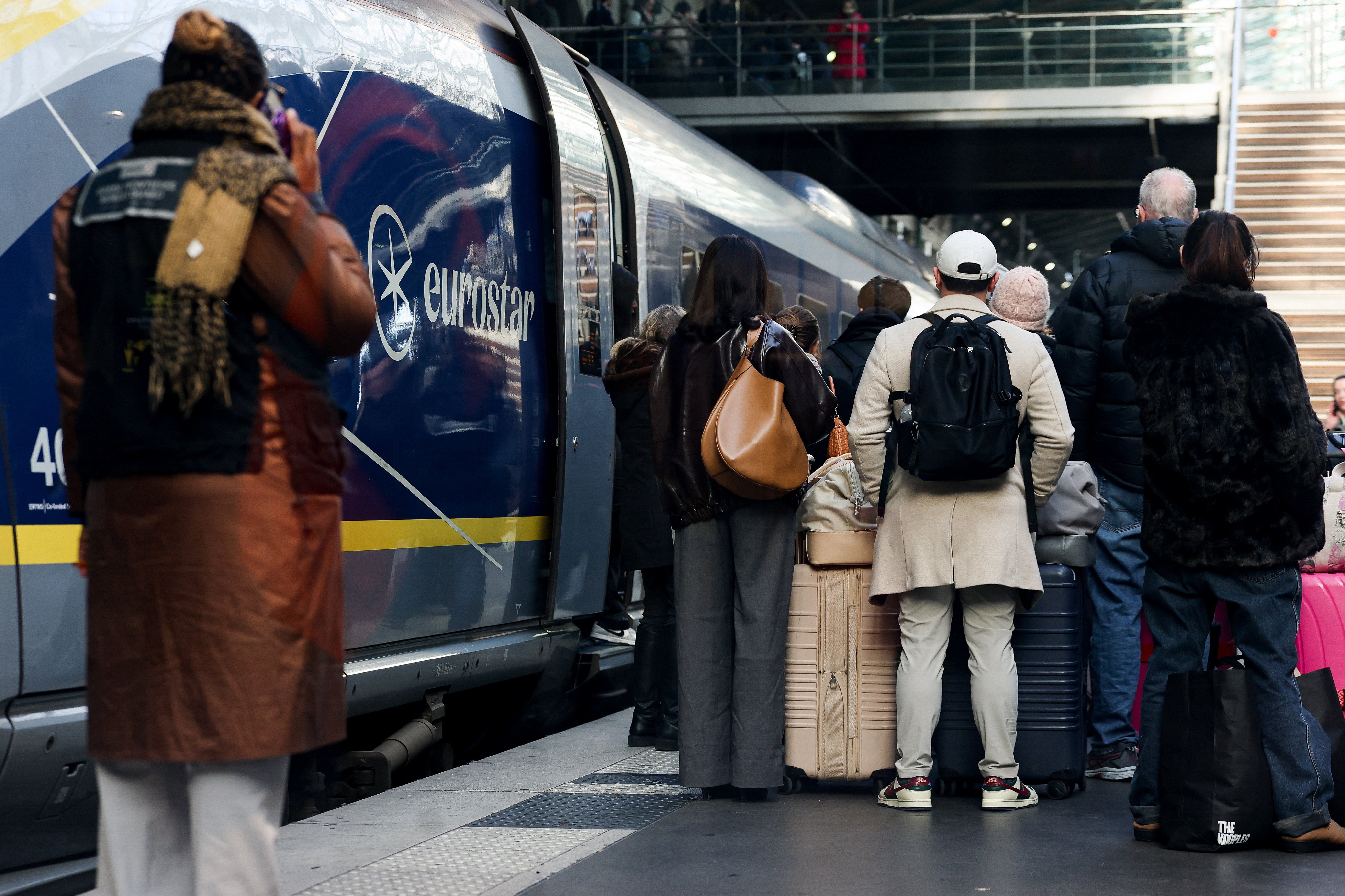 People stand next to a Eurostar train at Gare du Nord station after services are cancelled
