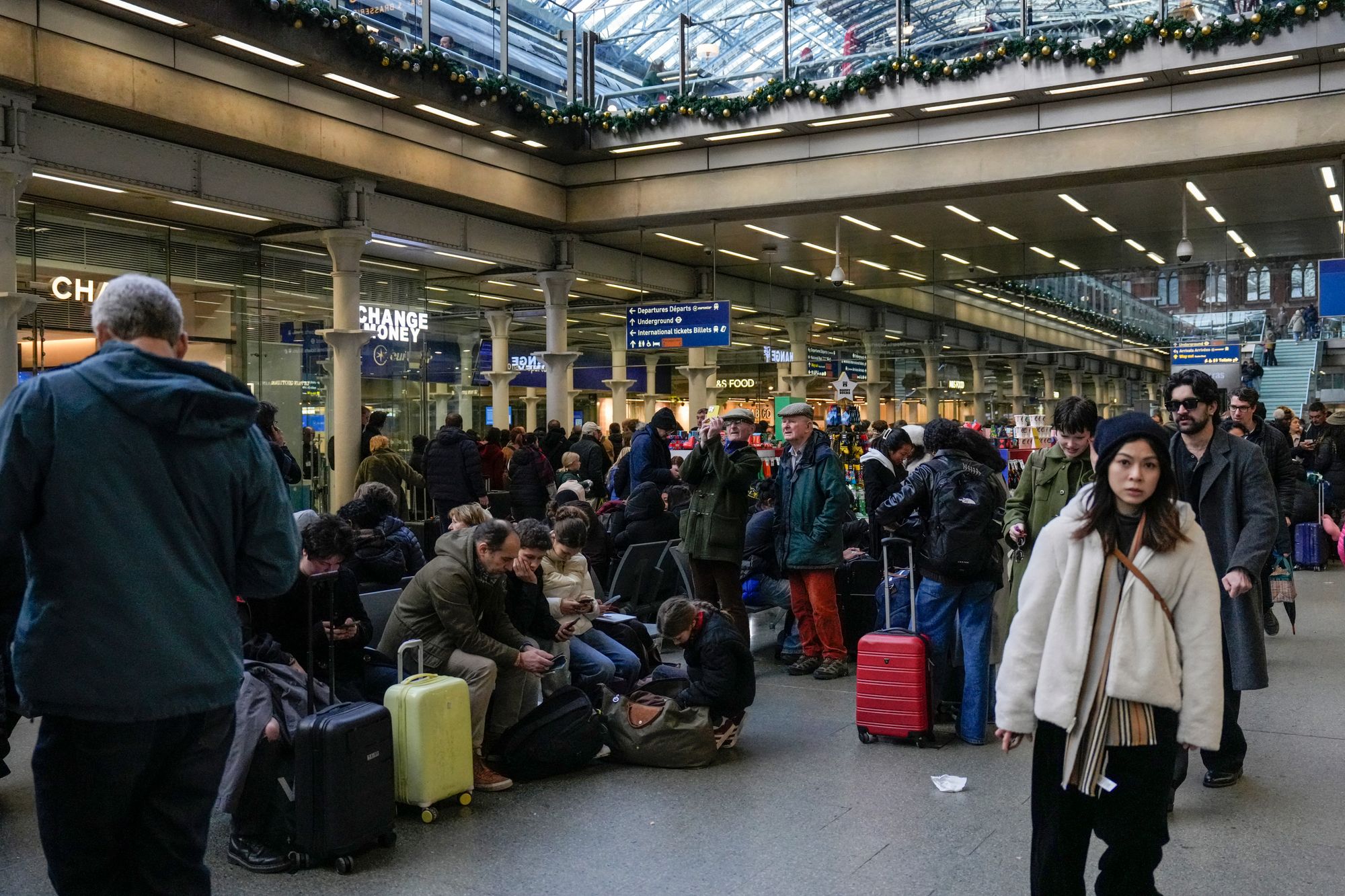 People wait with their bags at St. Pancras station in London as Eurostar trains are halted
