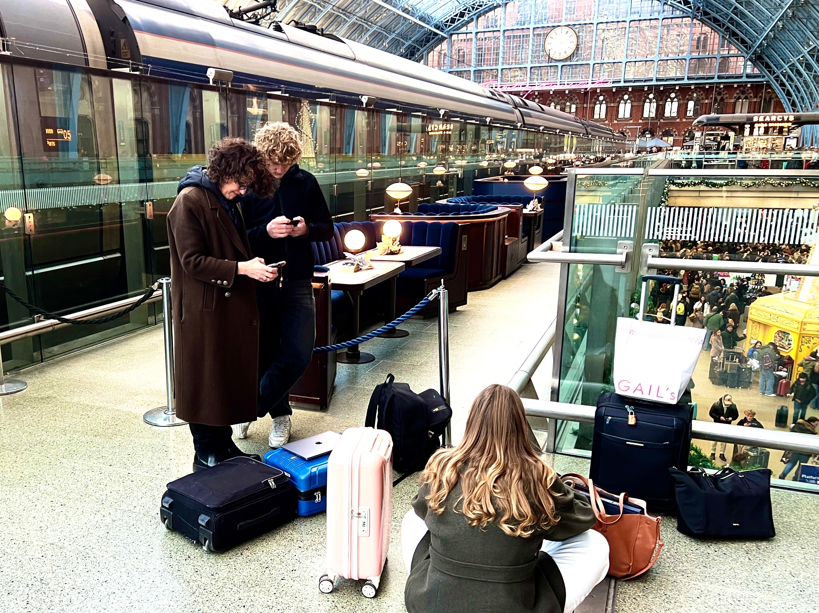 Passengers beside a Eurostar train trying to book flights