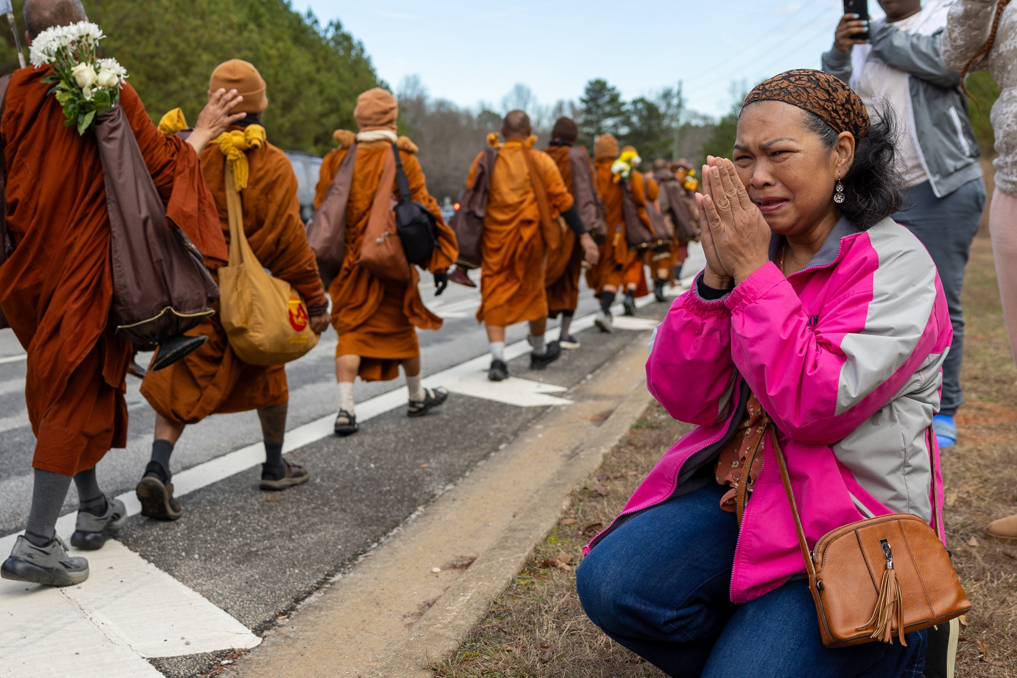 A woman reacts as Buddhist monks on a ‘Walk for Peace’ trek on Veterans Parkway in Fayetteville, Ga., on Monday, Dec. 29, 2025