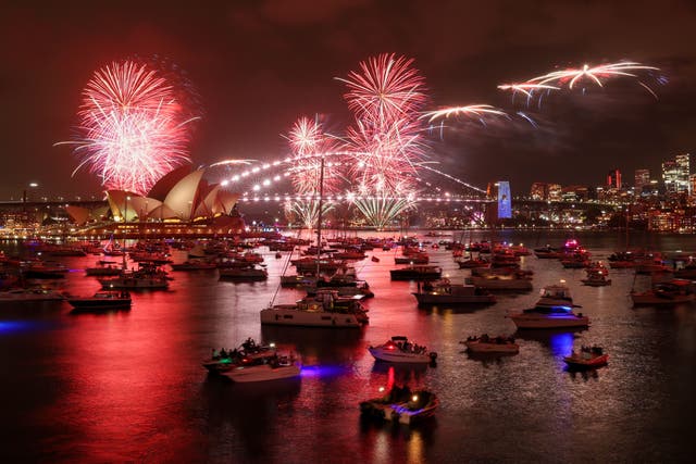<p>The ‘family fireworks’ fill the sky over the Opera House and Sydney Harbour Bridge in Sydney on New Year’s Eve in Sydney, Australia</p>