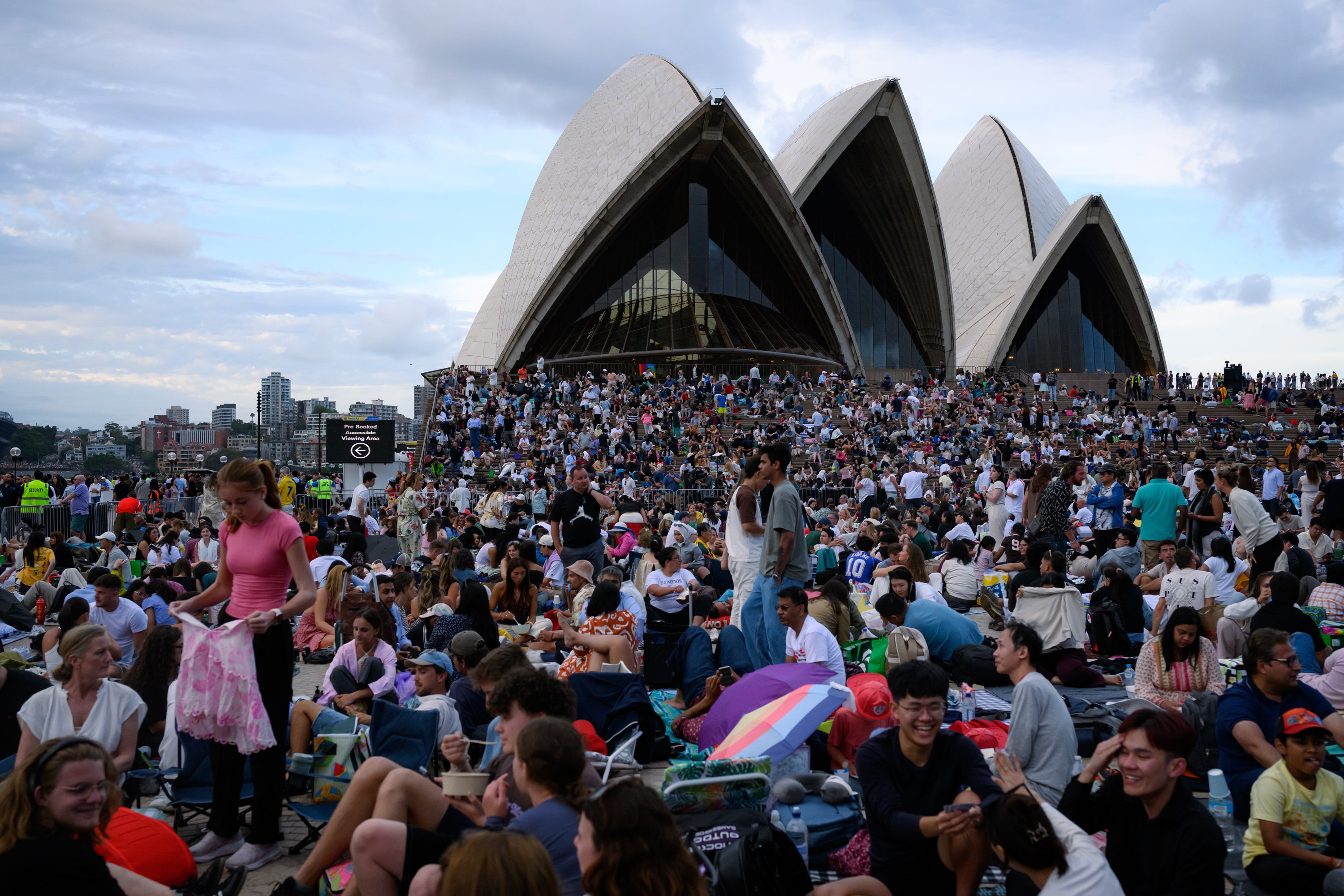 People gather at the Sydney Opera House in anticipation of the annual New Year's Eve fireworks display on December 31, 2025 in Sydney, Australia