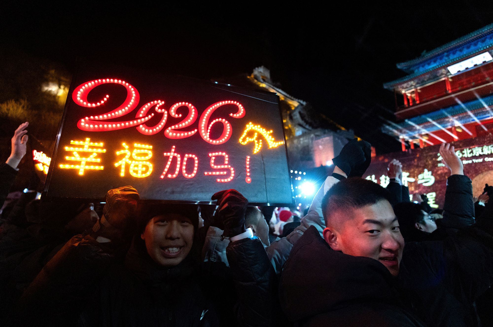 A man holds a board with the digits 2026 and a depiction of a horse, the symbol of the upcoming year, during a New Year countdown ceremony at the Juyongguan section of the Great Wall, also known as Juyong Pass, in Beijing, China.