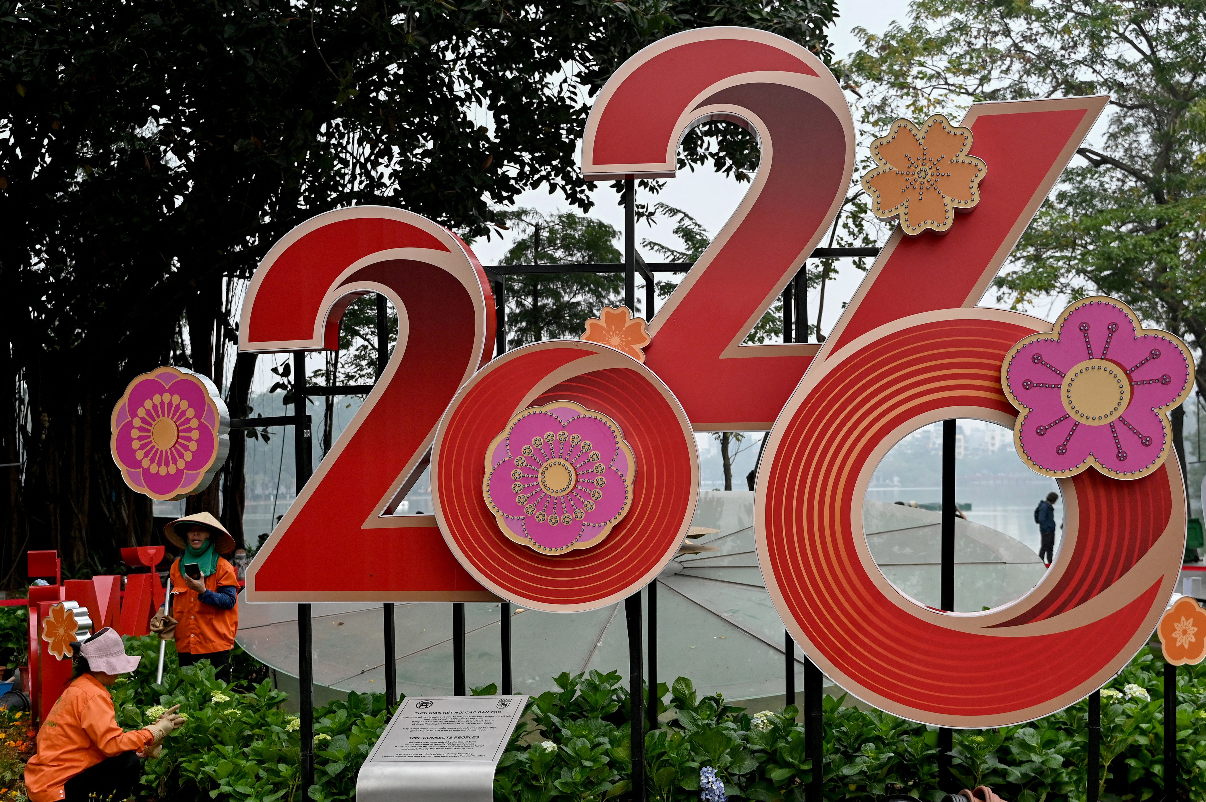 <p>Workers tend to flowers next to a 2026 New Year banner in Hanoi </p>