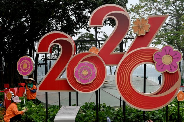 <p>Workers tend to flowers next to a 2026 New Year banner in Hanoi </p>