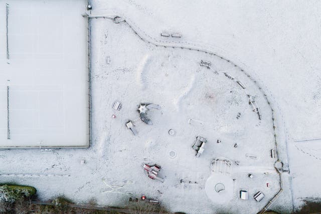 Snow covers a playground and tennis courts in Warwickshire (Jacob King/PA)