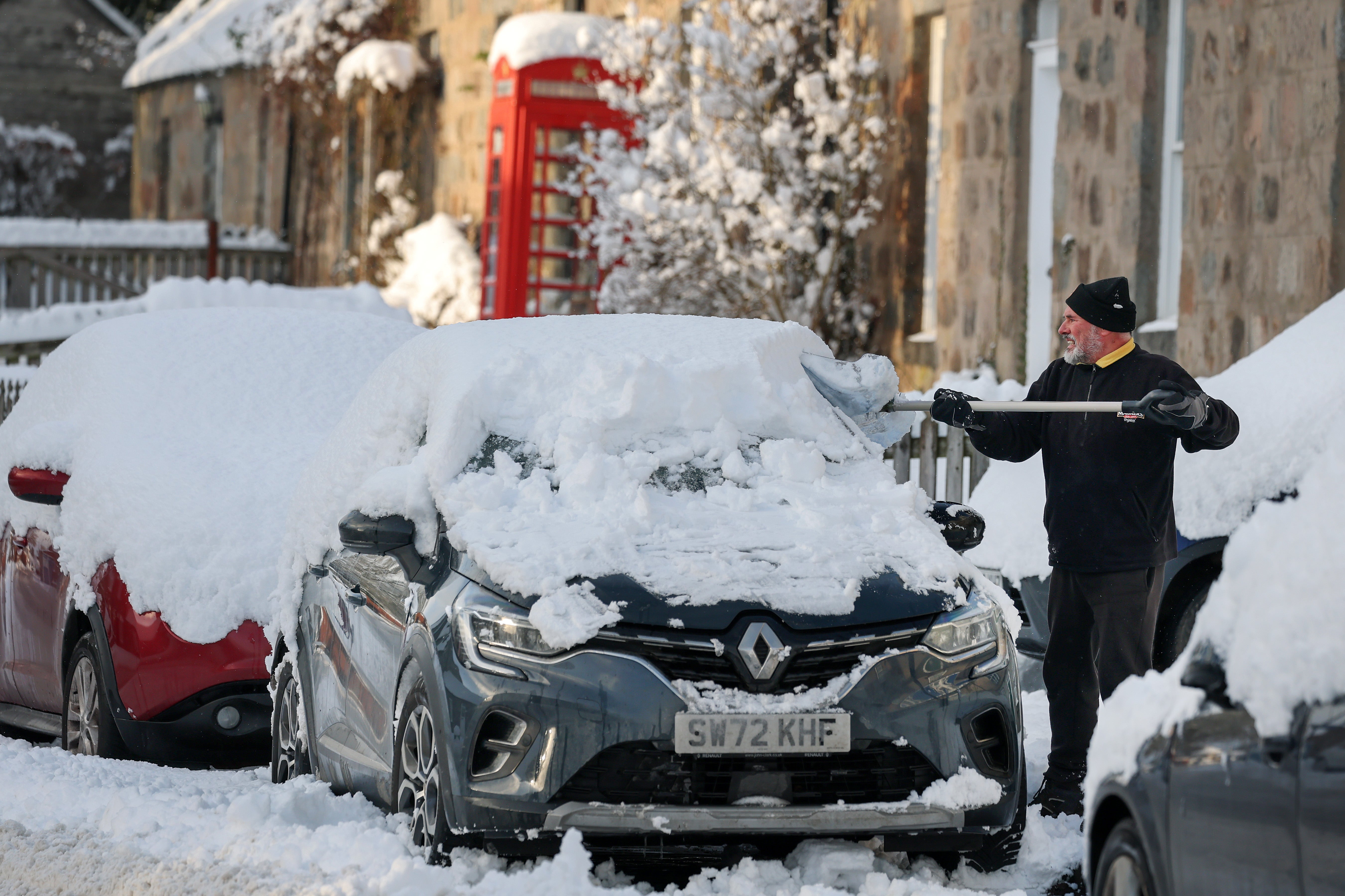 A man shovels snow as an 'amber' snow warning was issued on January 02, 2026 in Kincardine O'Neil, Scotland (Photo by Jeff J Mitchell/Getty Images)