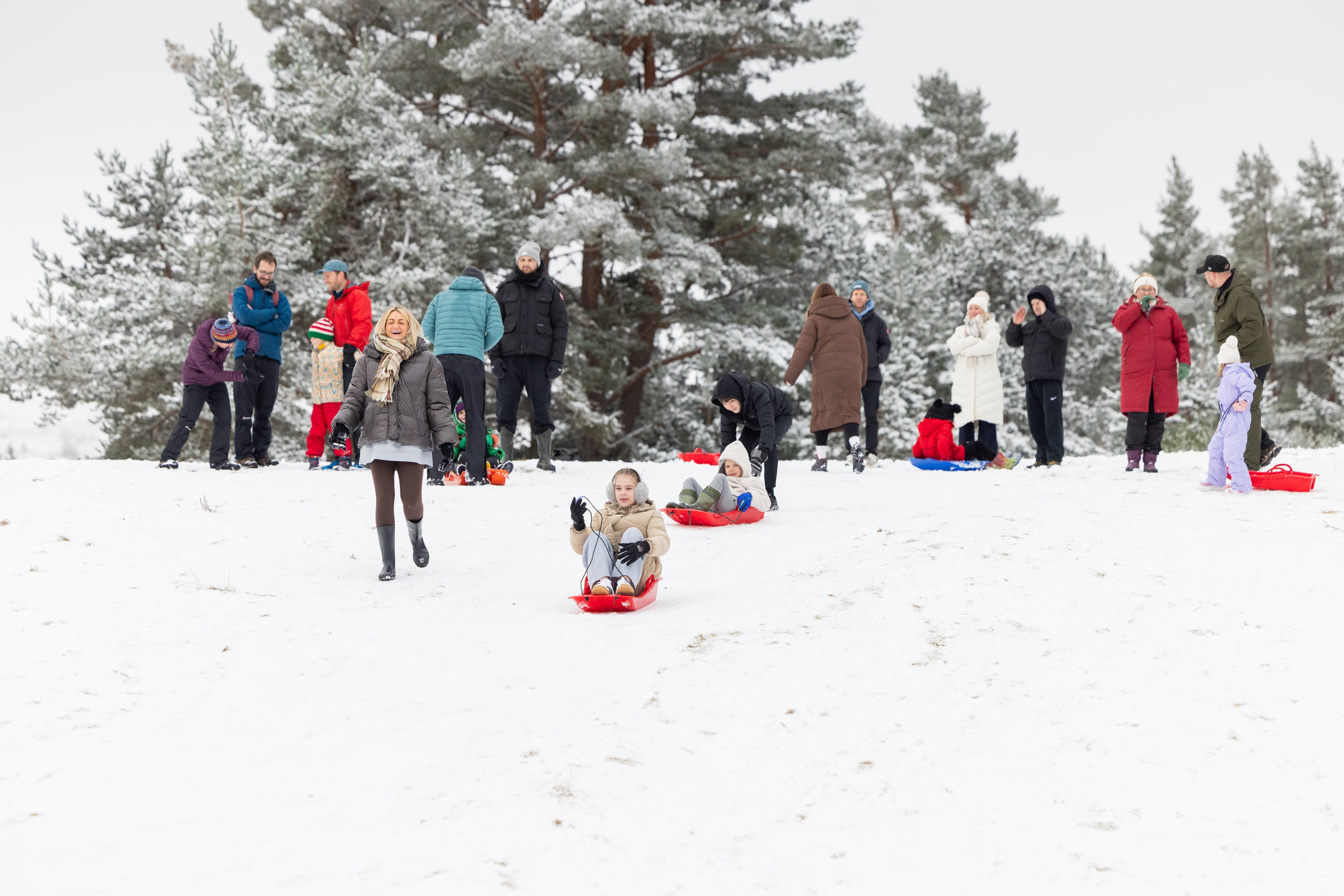 <p>People sledging in Loch Morlich, Aviemore as parts of the UK wake up to flurries of snow and ice</p>