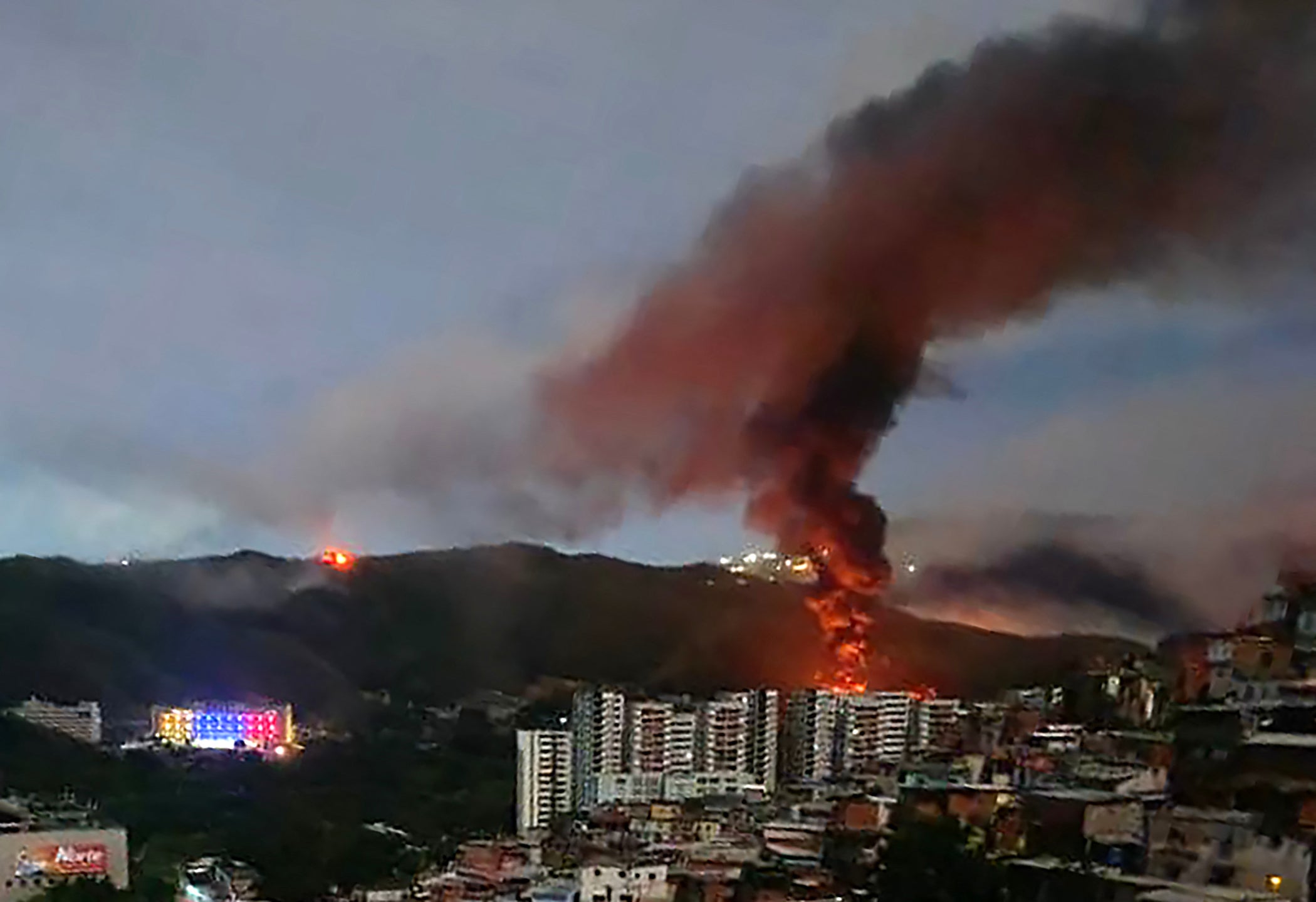 Fire at Fuerte Tiuna, Venezuela's largest military complex, is seen from a distance after a series of explosions in Caracas on January 3, 2026