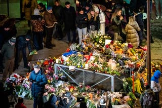 Mourners gather at a makeshift memorial near the site of a fire that ripped through a bar during New Year's Eve celebrations in the Alpine ski resort town of Crans-Montana killing around 40 people