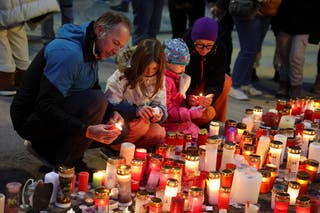People light candles outside the Le Constellation bar, after a fire and explosion during a New Year's Eve party