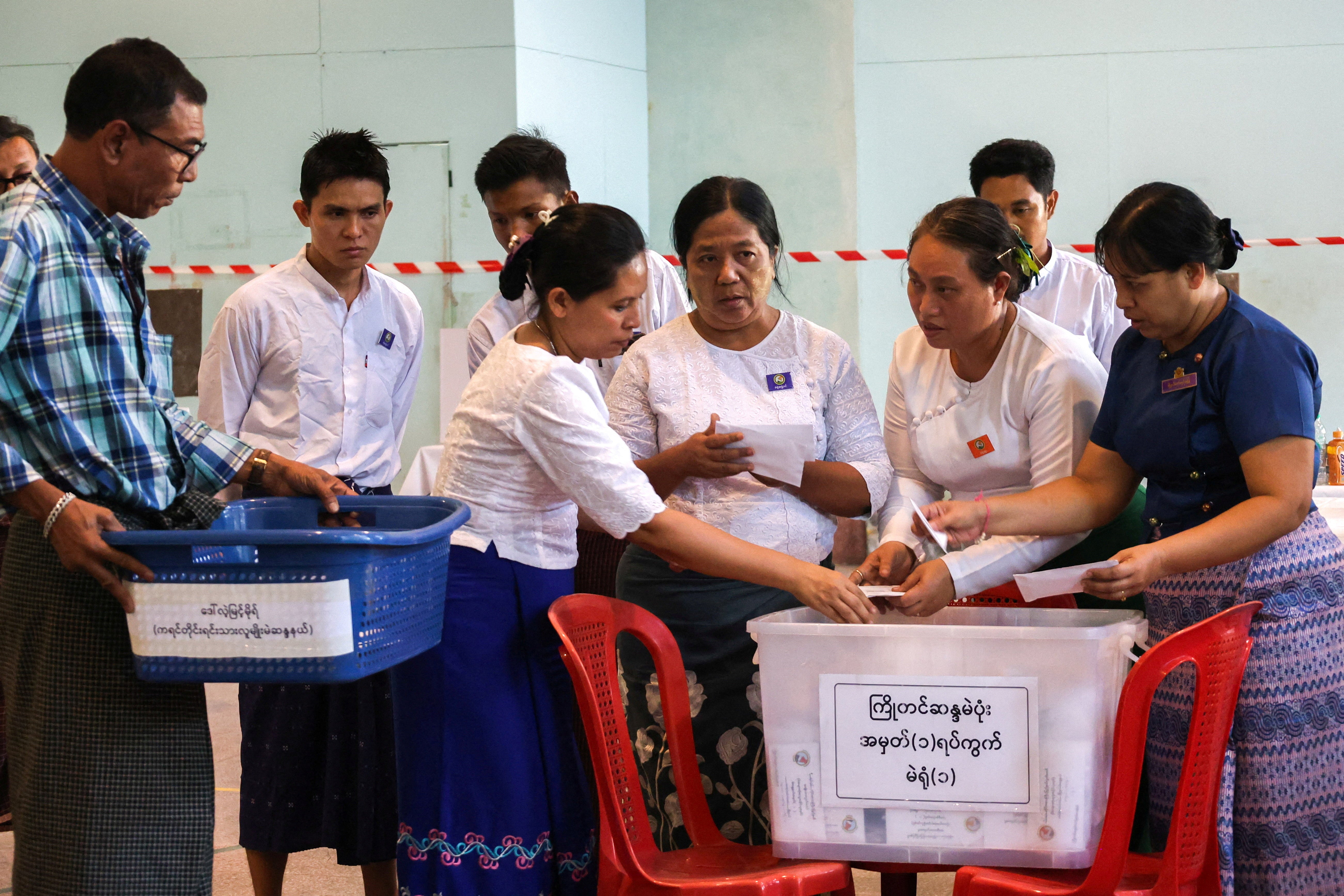 Election commission officials count ballots at a polling station in Yangon, Myanmar