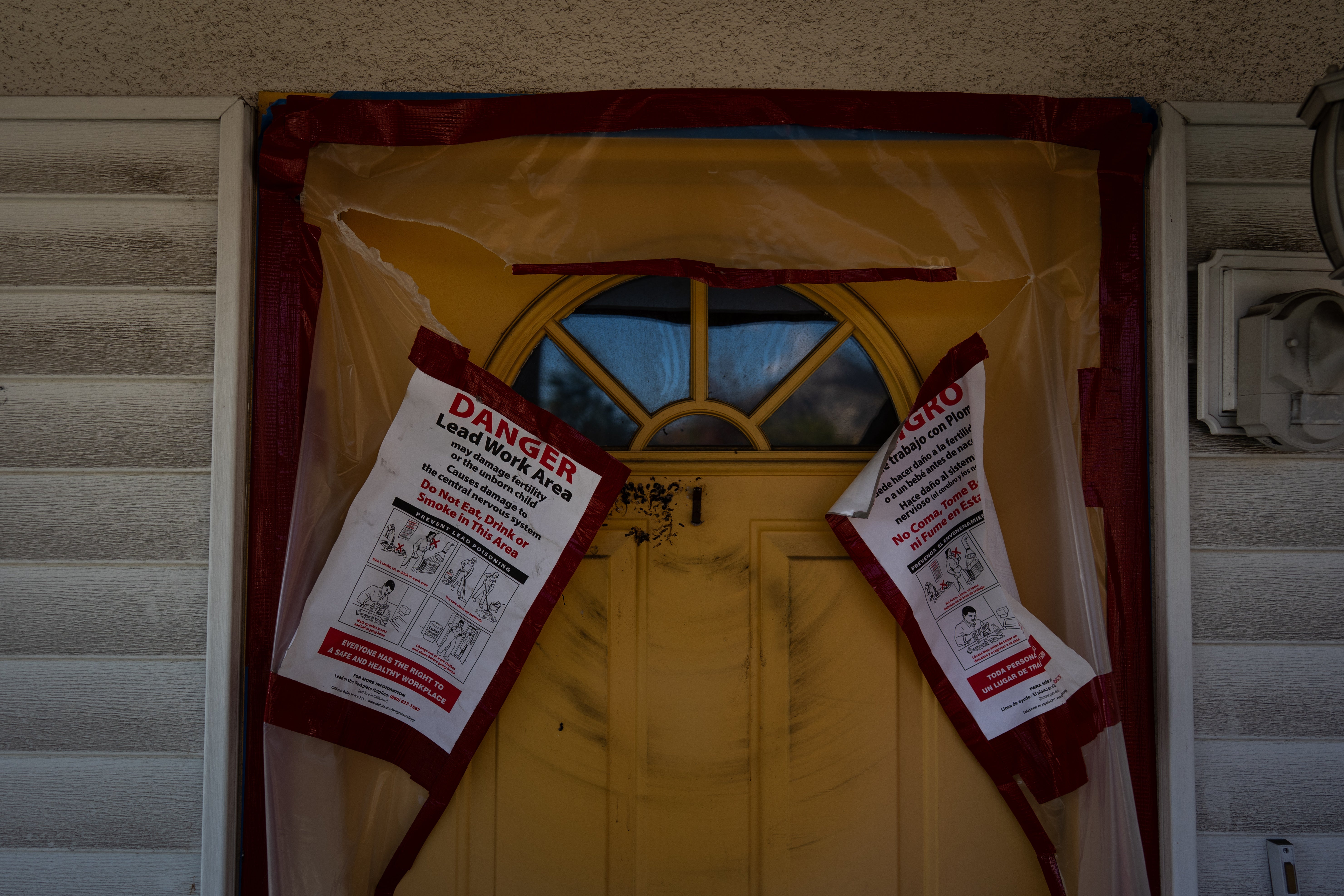 Warning notices are posted on the door of a home that survived the Eaton Fire, Dec. 3, 2025, in Altadena, Calif.