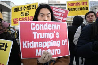 Protesters hold placards during a demonstration condemning the US attack on Venezuela and the seizure of Venezuelan leader Nicolas Maduro, in front of the US embassy in Seoul