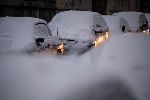 <p>Snow-covered cars are parked in a street in Budapest, Hungary</p>