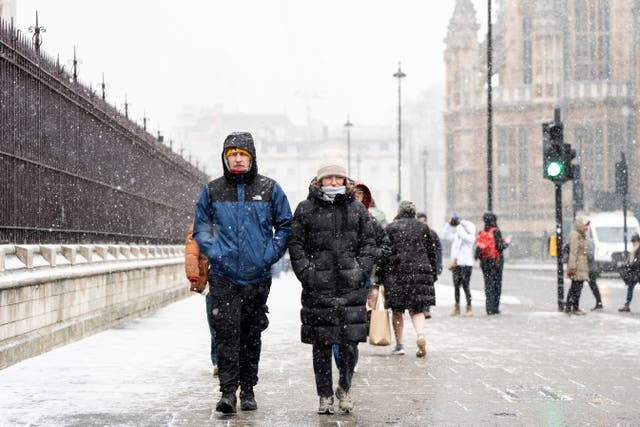 <p>People in the snowy conditions in Westminster, central London</p>